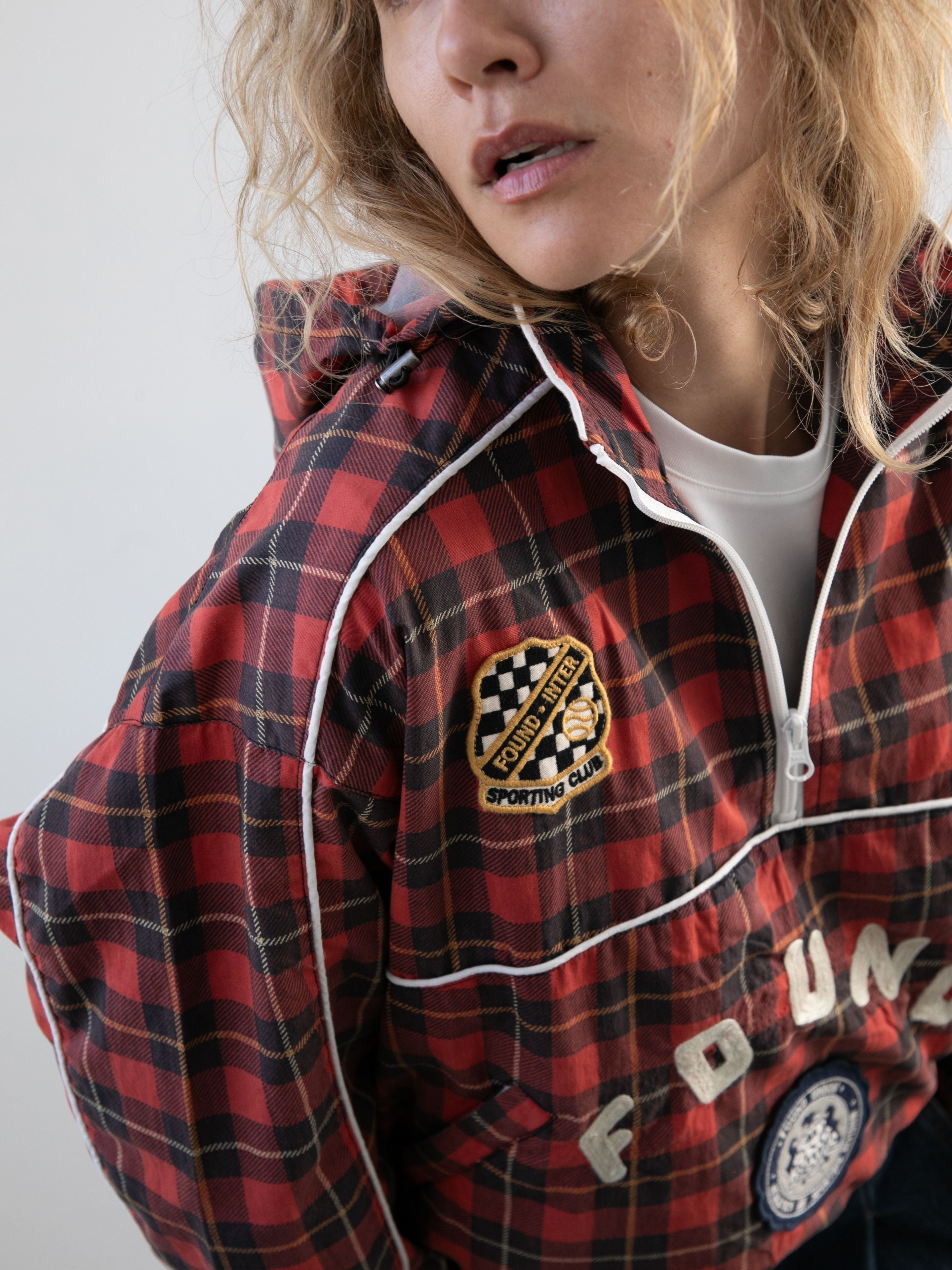 Wearing the FOUND Red Plaid Track Jacket with a white shirt for a classic vintage sport look, featuring signature WHITE piping and brand detailing.