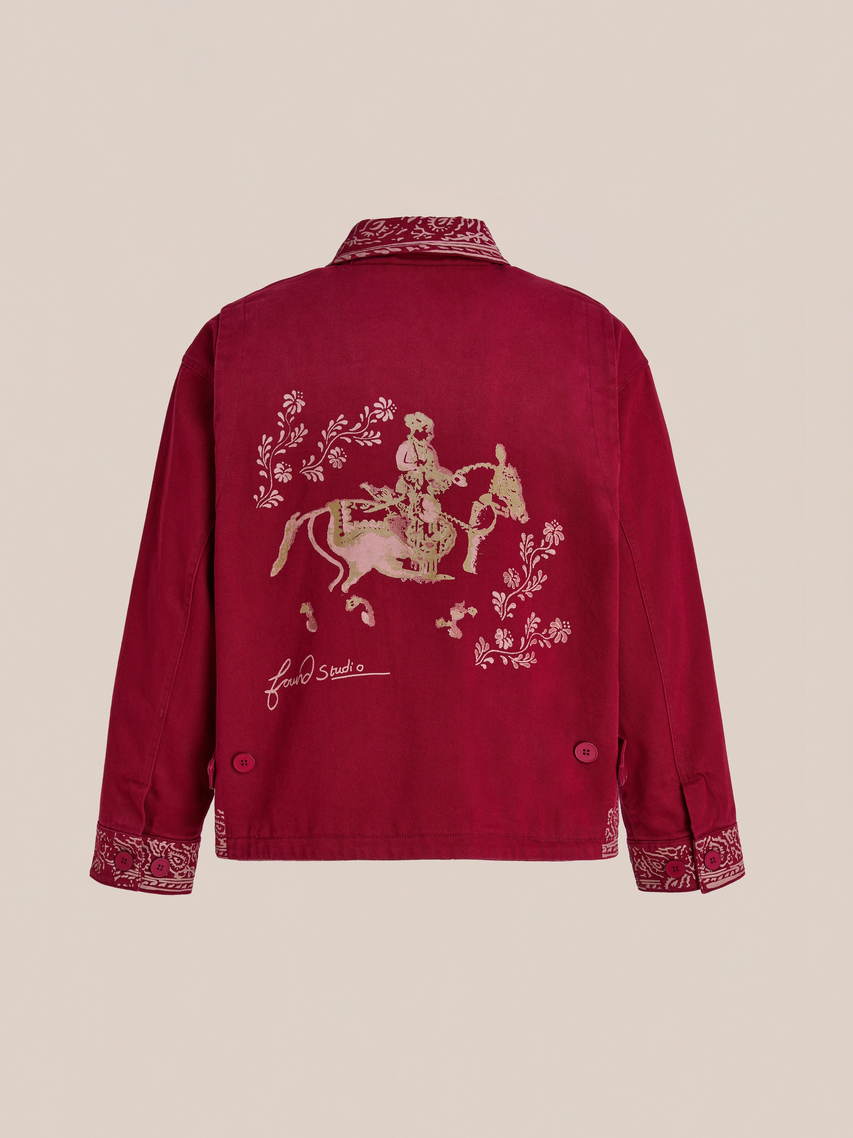 The Found Abhala Printed Work Jacket is a unisex relaxed fit in red, with equestrian motifs and a floral horse rider illustration on the back, embroidered cuffs, and a signature below the artwork.
