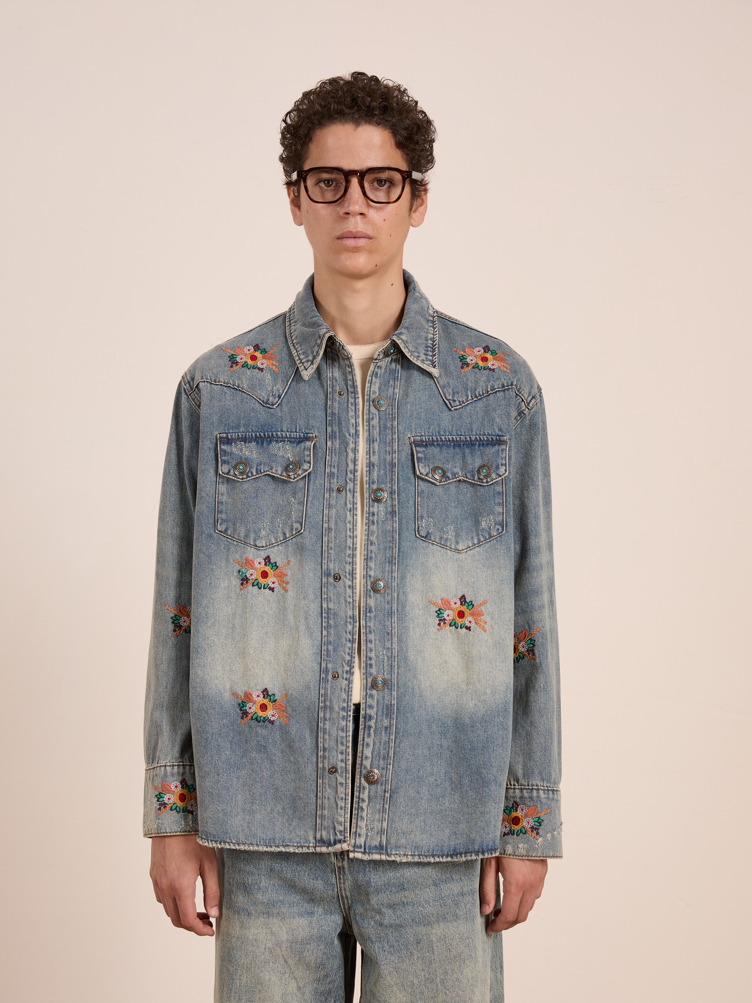 A person wearing glasses and the FOUND Bouquet Floral Embroidered Western Denim Shirt stands against a plain background.