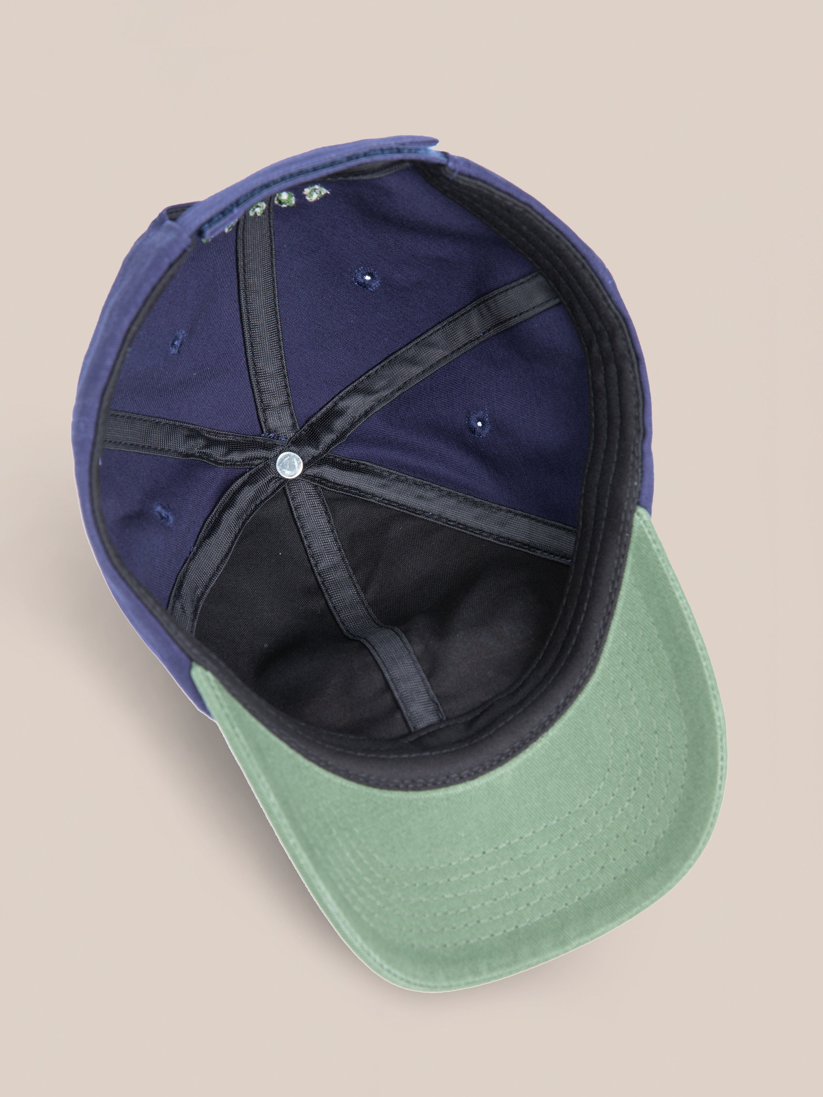 The Horse Equine Cap by Found showcases 70's color-blocking with blue and green hues, revealing its interior panels and intricate stitching when viewed from the inside.
