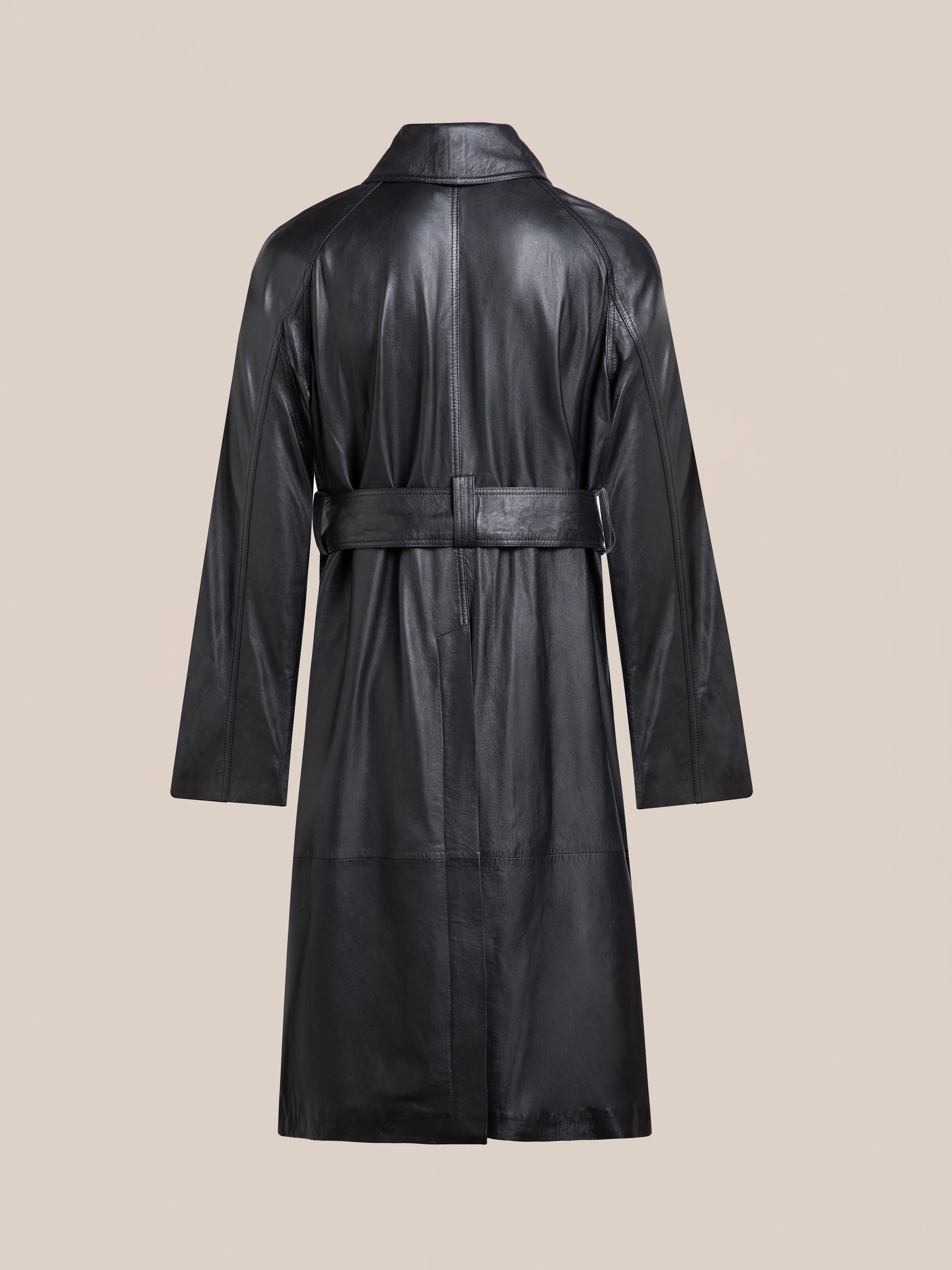 The FOUND Leather Trench Coat in black cowhide features a waist belt and is displayed from the back against a plain beige background.