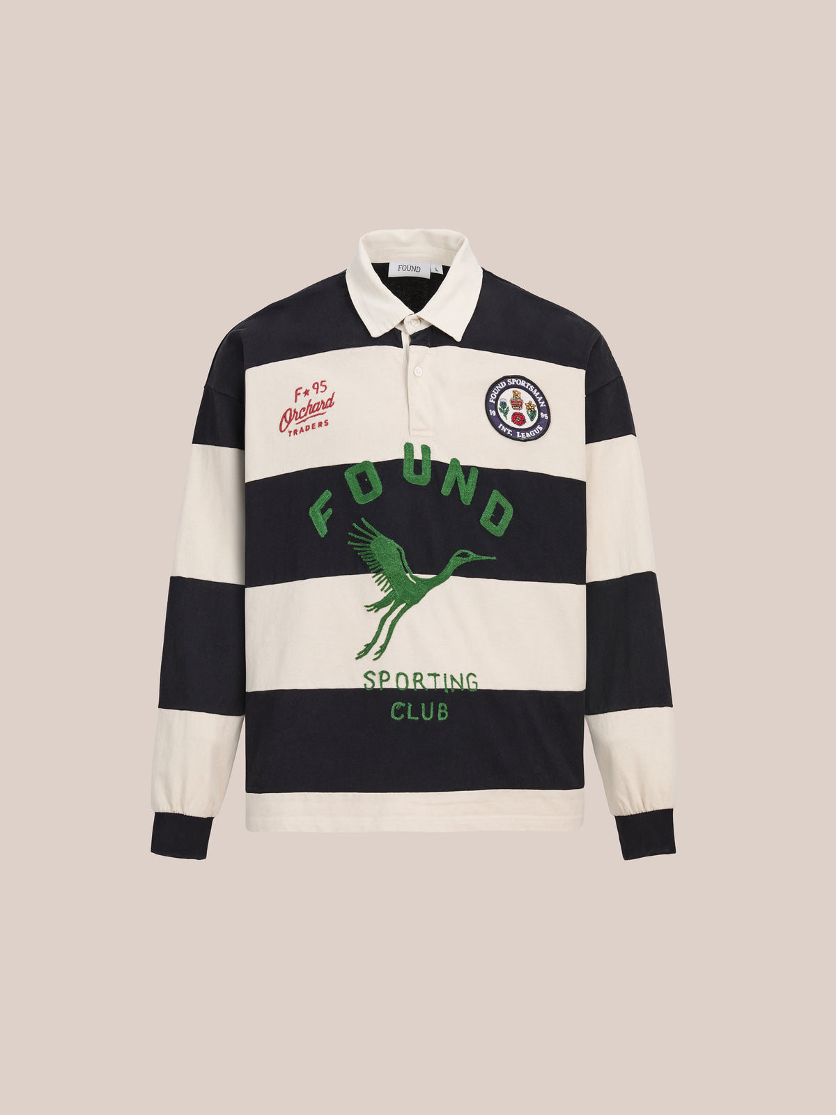 FOUND Bird Logo Rugby: Unisex relaxed fit shirt with navy/white stripes, long sleeves, collar, green “Found Sporting Club” text, crane graphic, and red/white chest patches.