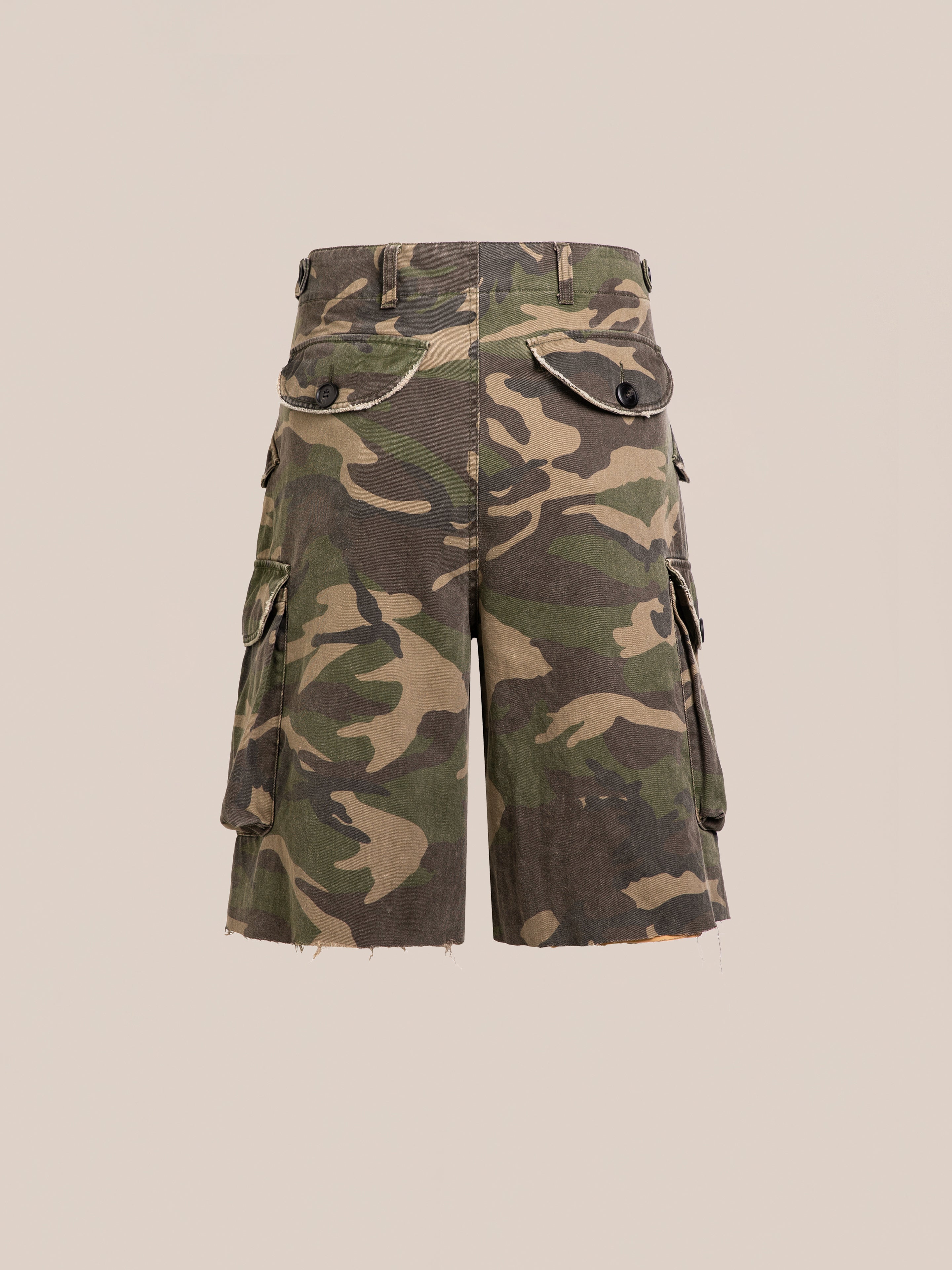 FOUND Camouflage Twill Utility Cargo Shorts feature a unisex relaxed fit, raw unfinished hems, and multiple pockets. Displayed on a plain beige background, they offer a true vintage-inspired look.