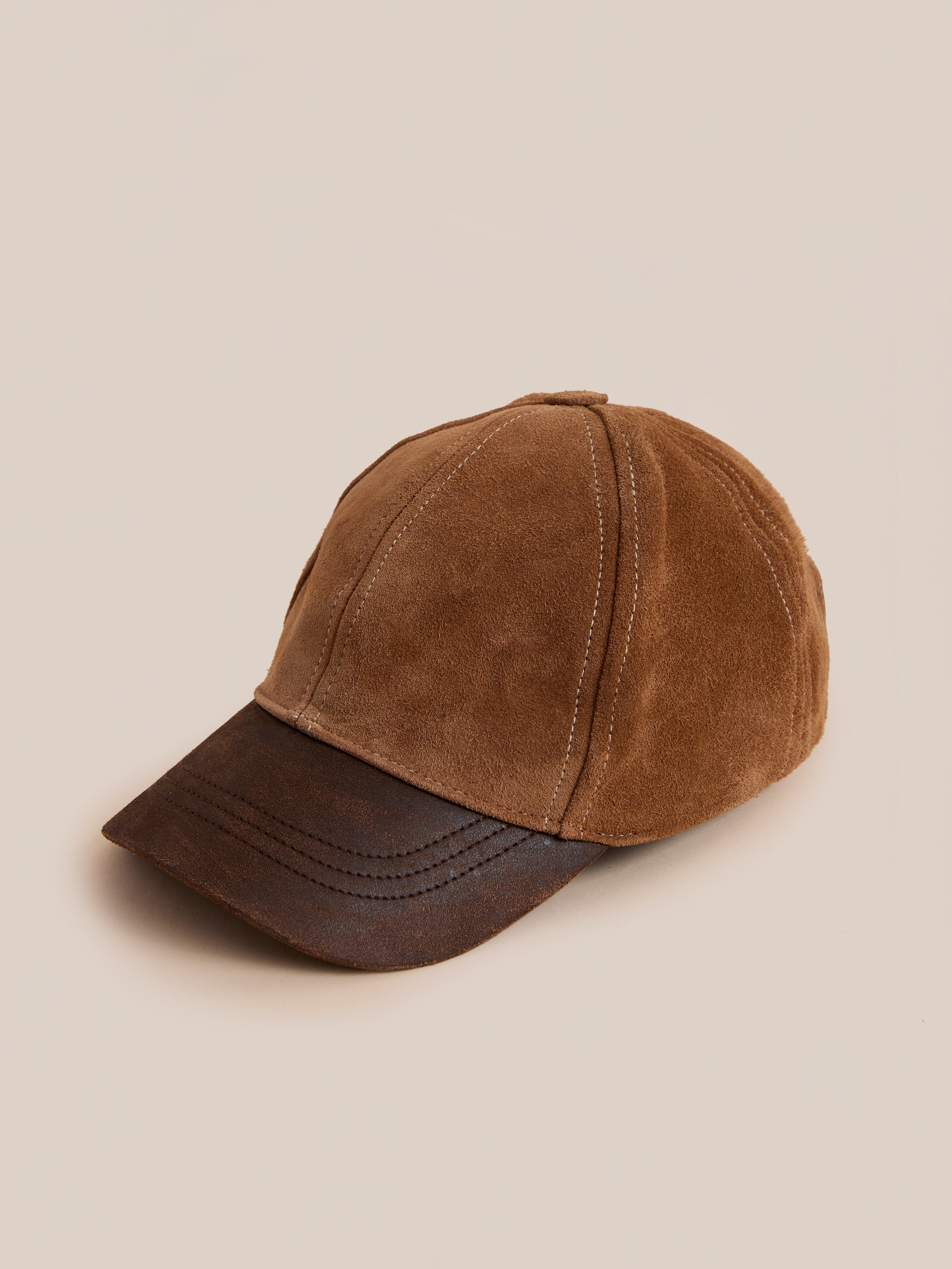 Found Suede Leather Contrast Distressed Cap featuring brown suede and a distressed brown leather brim, shown against a plain beige background.