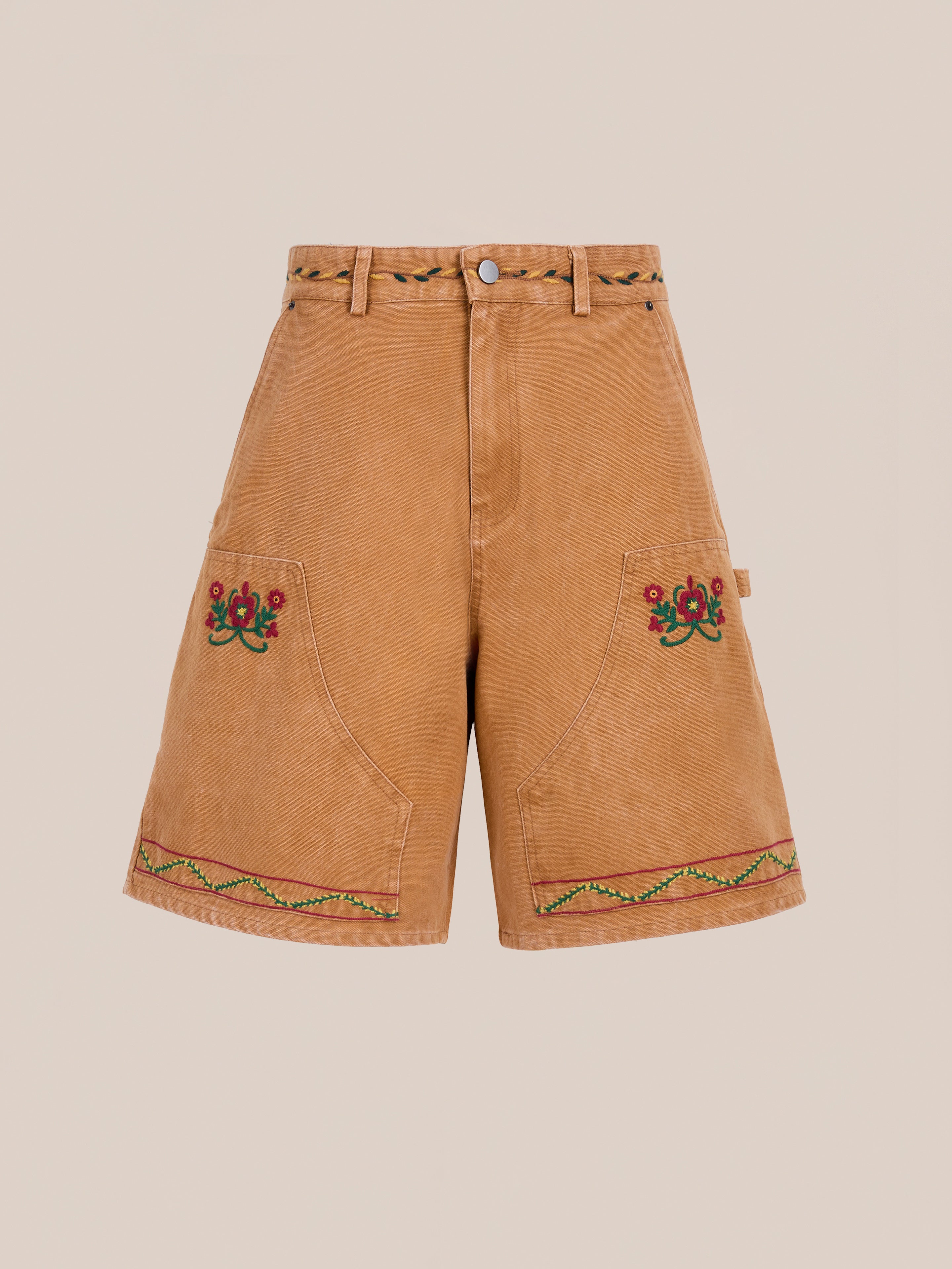 Found Canvas Embroidered Shorts feature a tan, high-waisted vintage canvas style with floral embroidery, front pockets, and a charming braided belt detail.