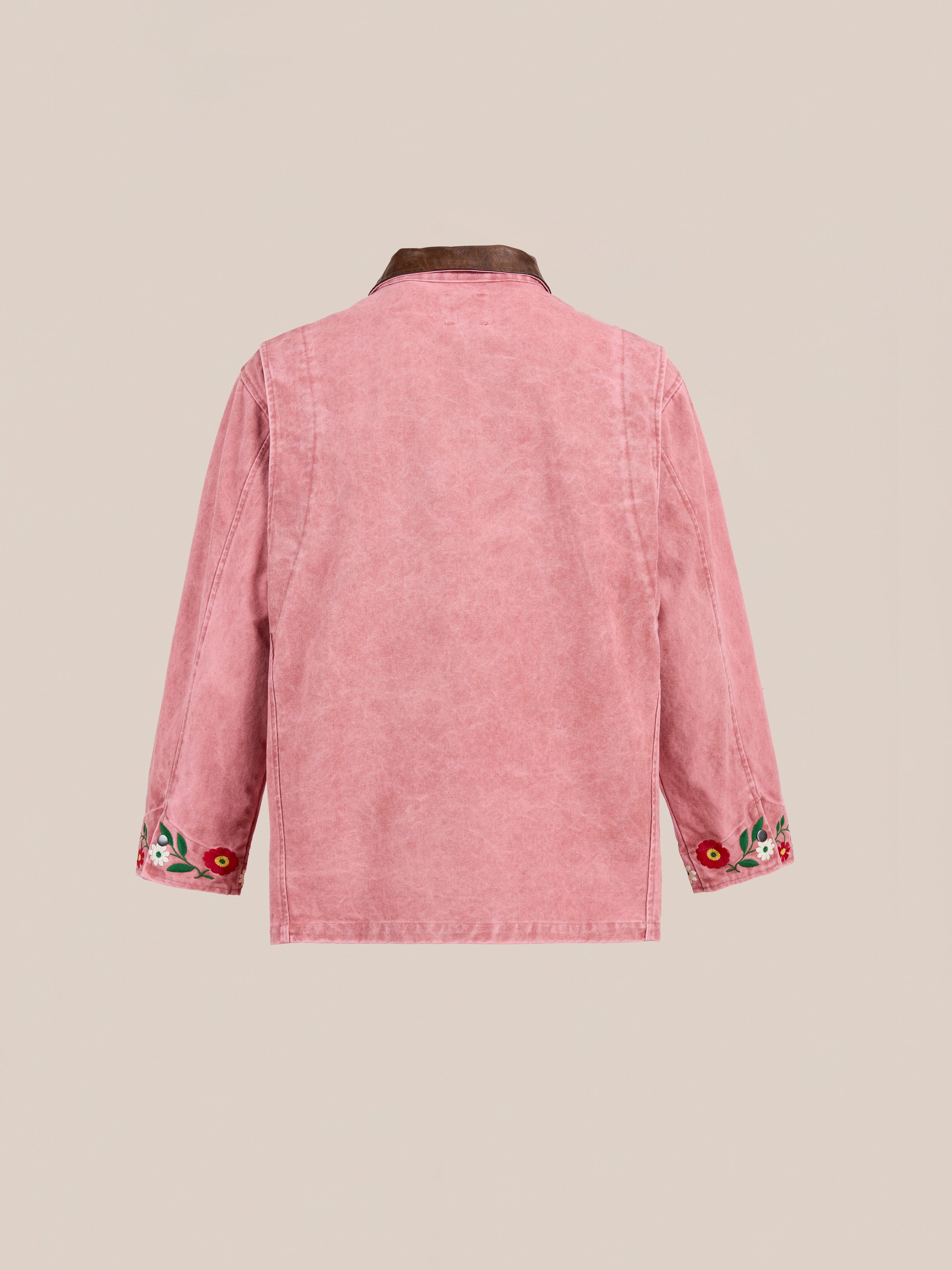 The Found Canvas Embroidered Barn Jacket features pink floral embroidery, a brown collar, and embroidered sleeve cuffs, inspired by vintage washed canvas styles. Shown from the back against a neutral background.