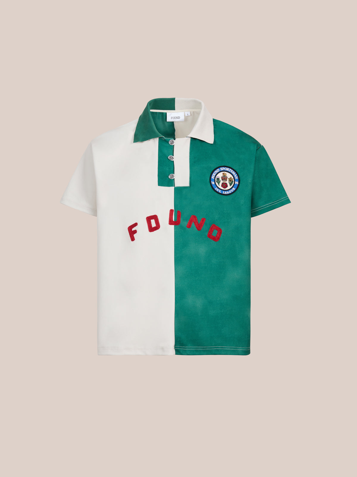 Color Block Regent Jersey by FOUND—a short-sleeve collegiate polo shirt featuring a bold white and green color block jersey design, red “FOUND” lettering, and a circular chest patch, showcased on a plain background.