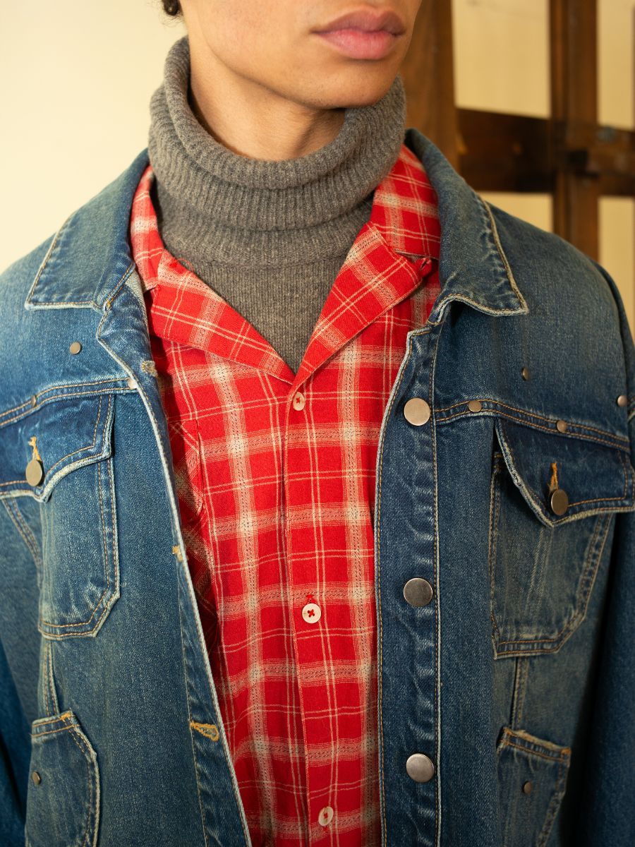 Showcasing a unisex relaxed fit ensemble with a gray turtleneck under a red plaid shirt and FOUND's Denim Carpenter Jacket, highlighting the timeless appeal of this workwear staple.