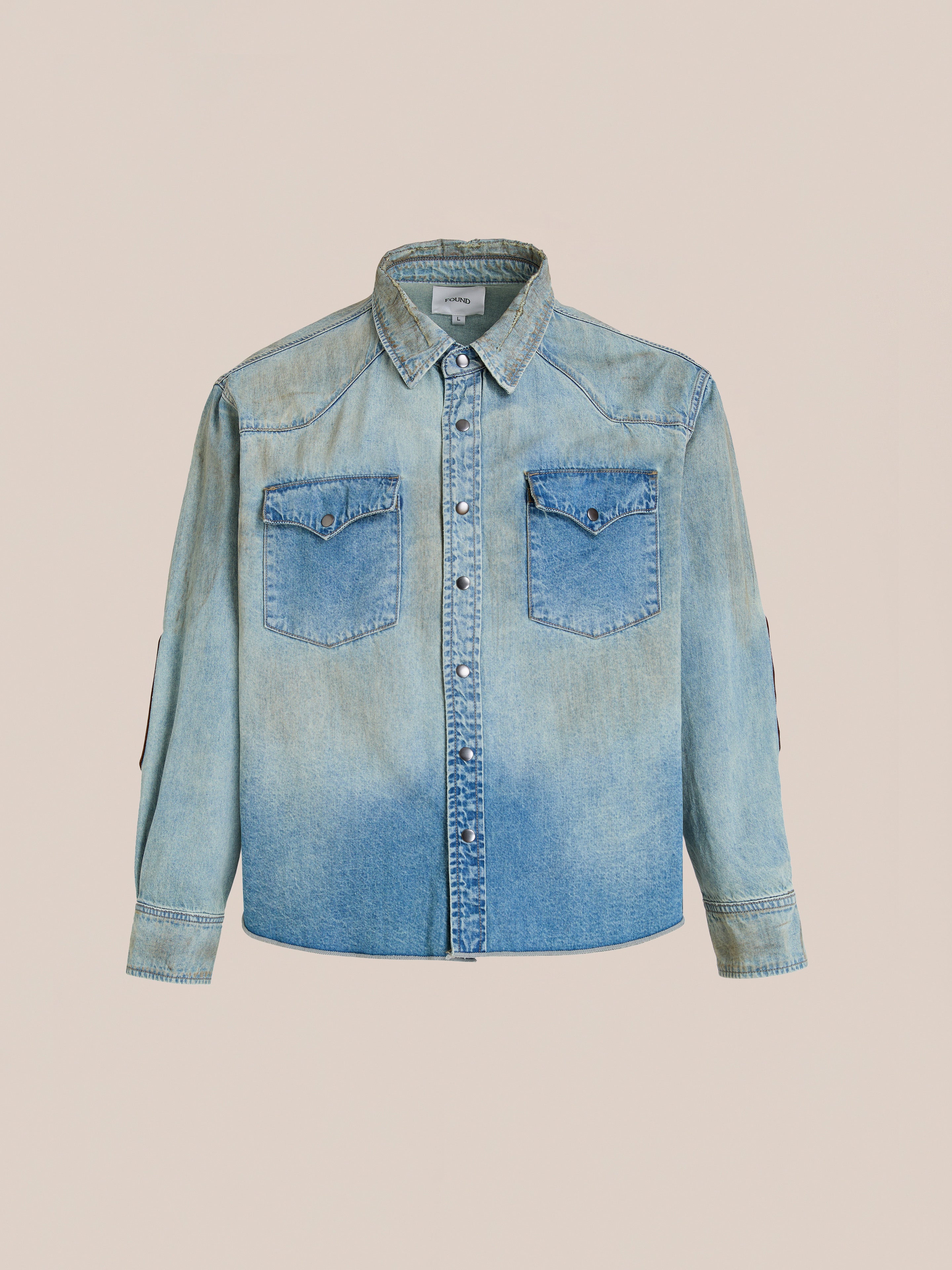 The FOUND Denim Western Snap Button Shirt is a unisex relaxed-fit, vintage-wash shirt with two chest pockets, long sleeves, and a gradient fade from light to dark blue.