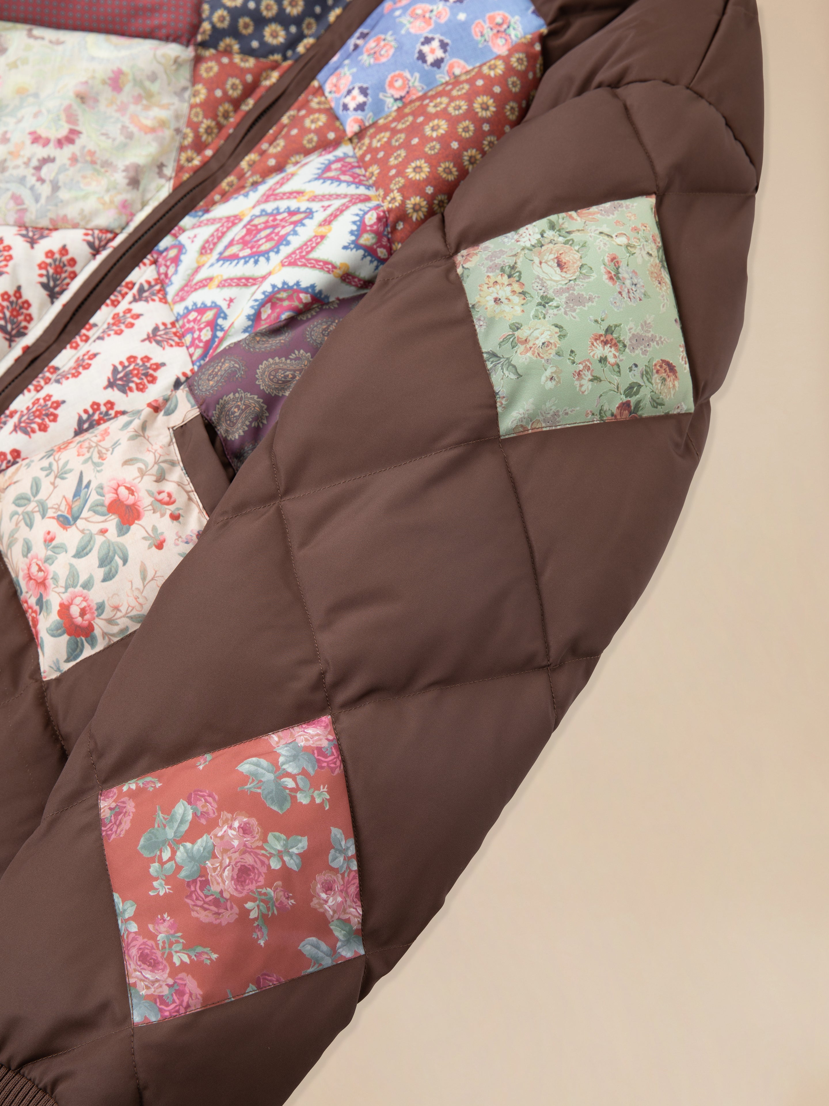 A brown Diamond Quilt Patchwork Jacket with floral patches on it, featuring South Asian prints by Found.