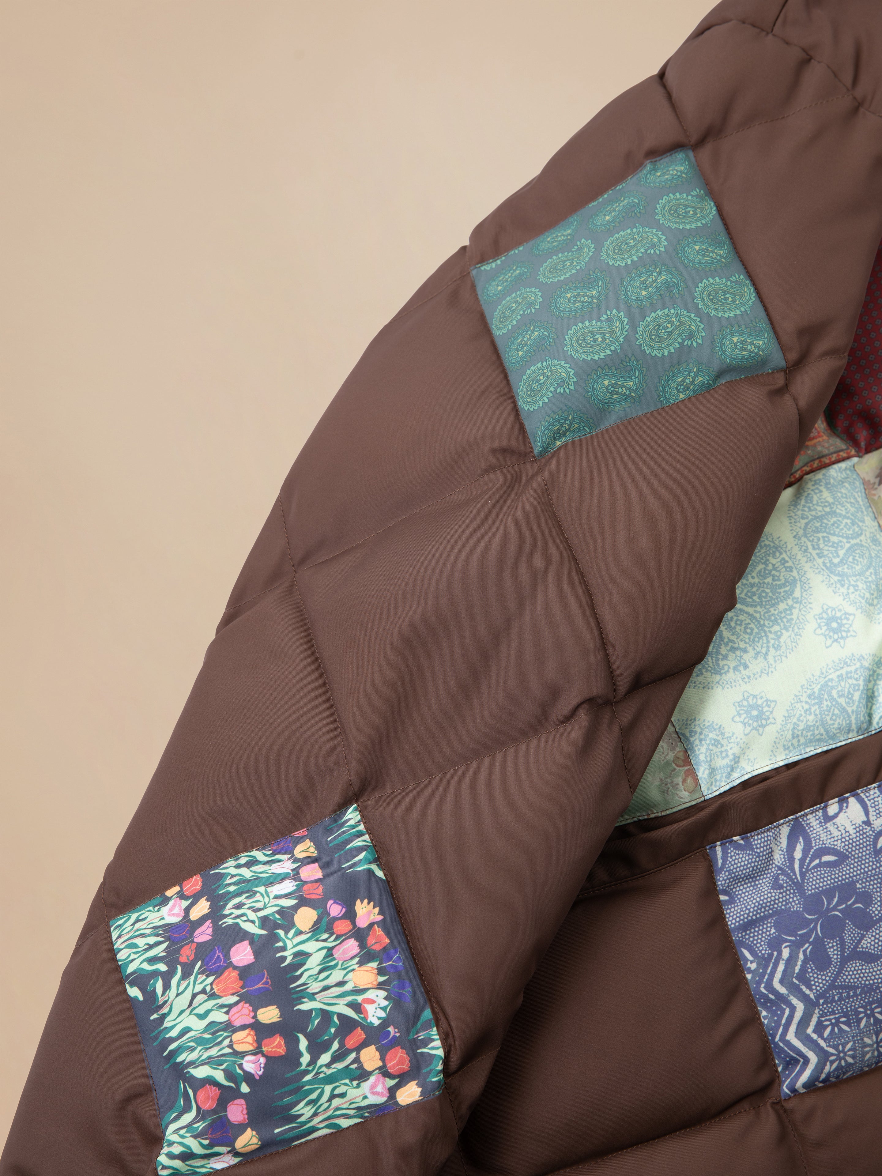 A brown Diamond Quilt Patchwork Jacket with a colorful South Asian patch by Found.