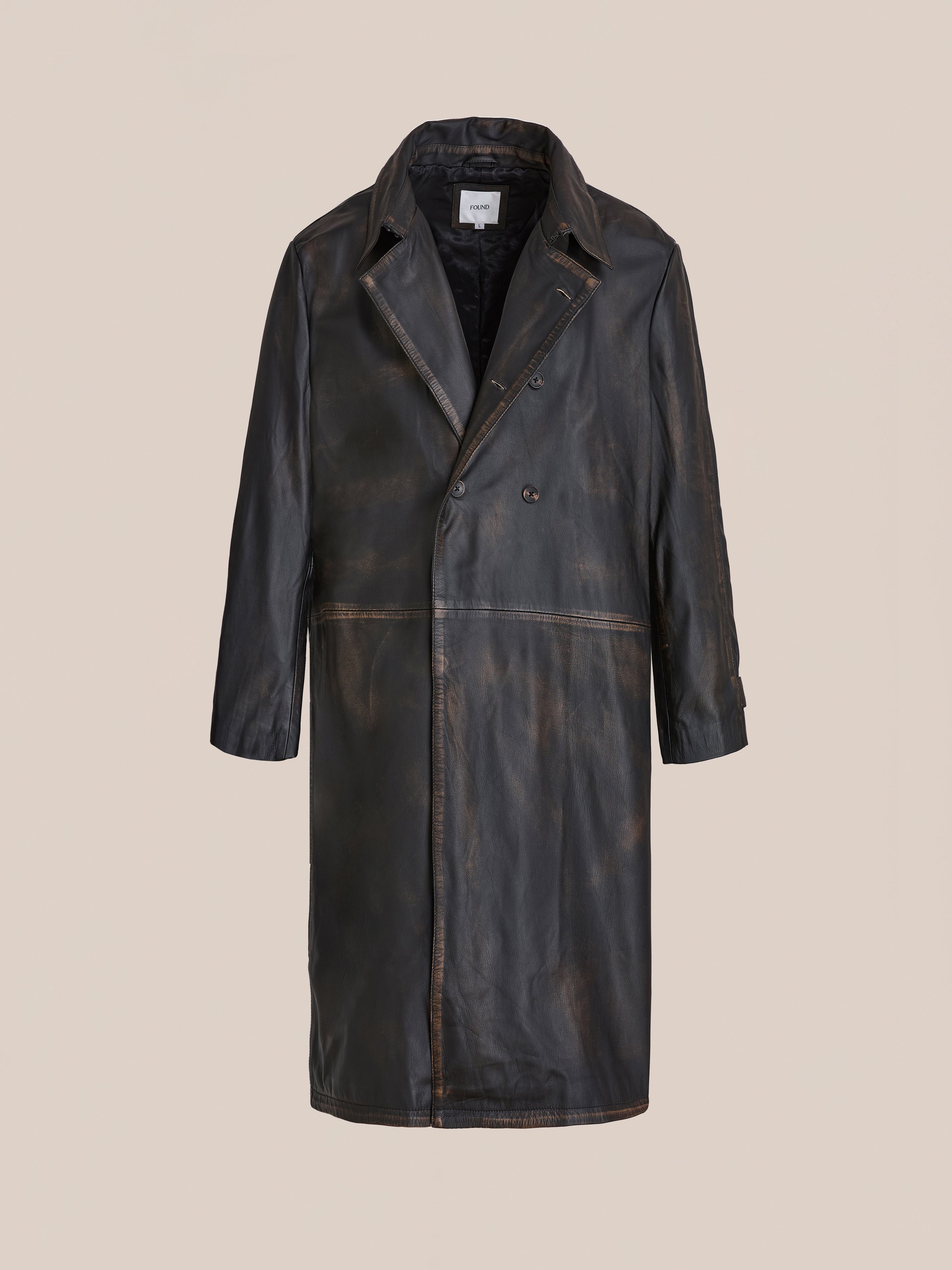 The FOUND Distressed Leather Trench Coat features a dark brown genuine leather finish with a notched collar, button closure, and visible seams, shown against a plain beige background.