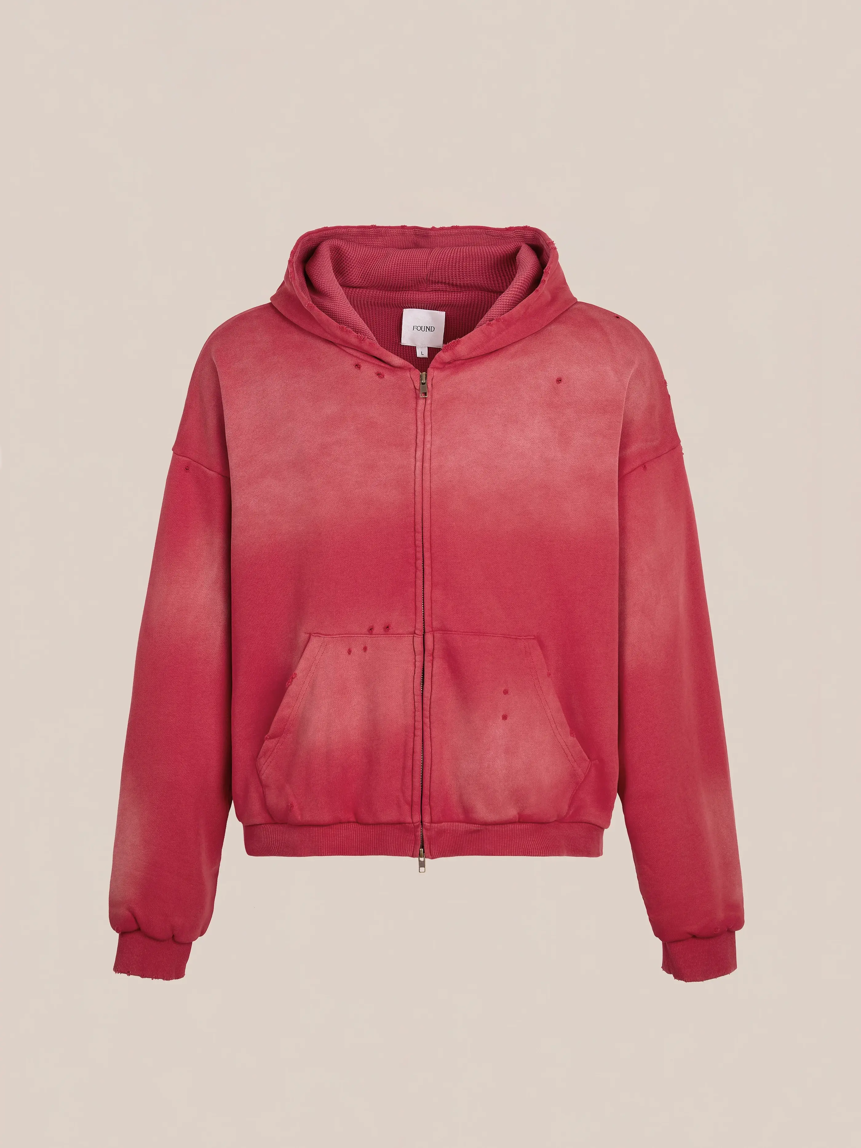 The FOUND Distressed Thermal Lined Zip Up Hoodie features a red faded look, unisex relaxed fit, front pockets, ribbed cuffs, and a hood, shown against a plain beige background.