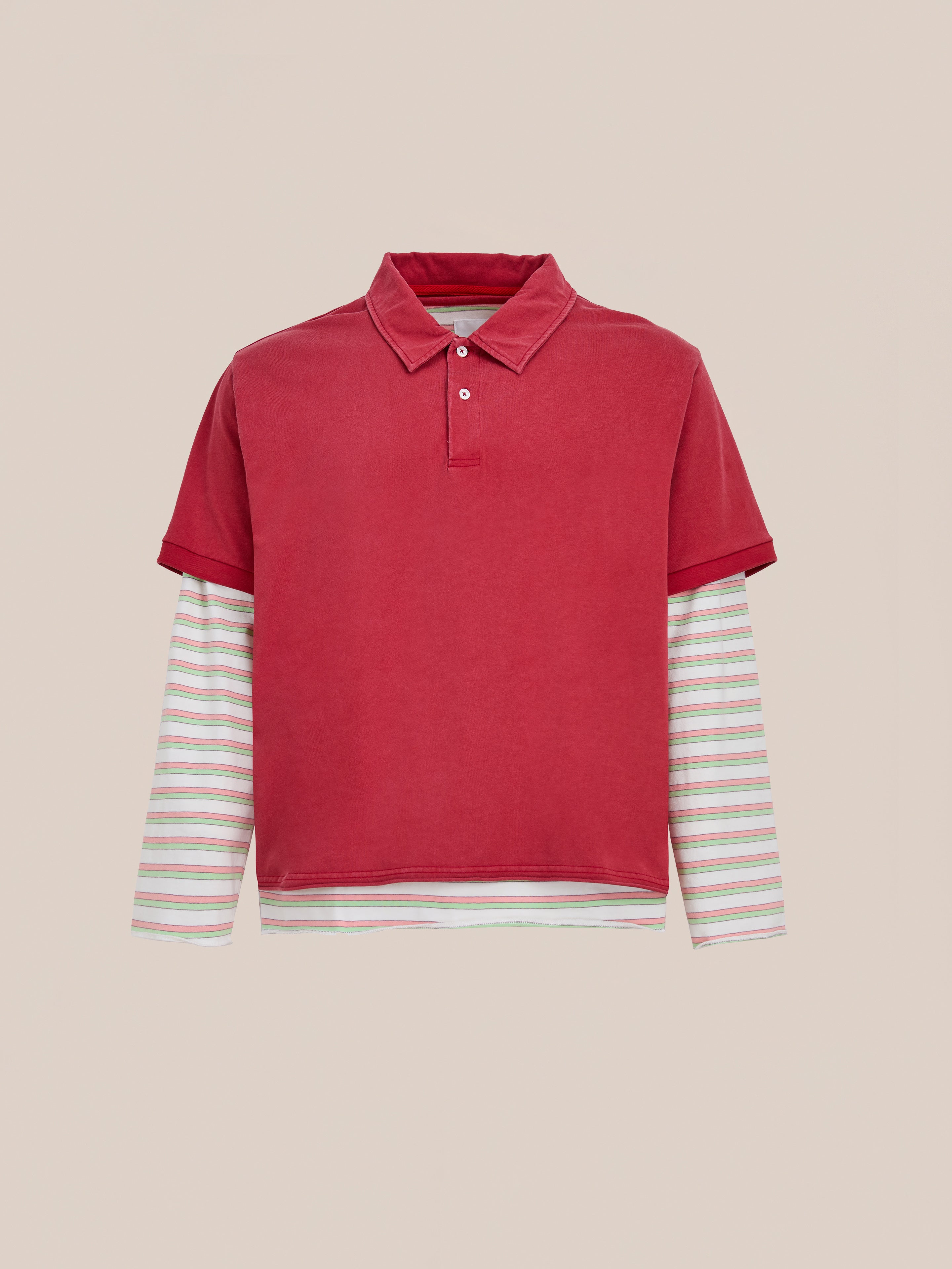 The FOUND Double Layer Stripe Polo is a unisex relaxed-fit piece featuring a red short-sleeve polo layered over a white long-sleeve shirt with pastel stripes, inspired by vintage athletic sportswear.