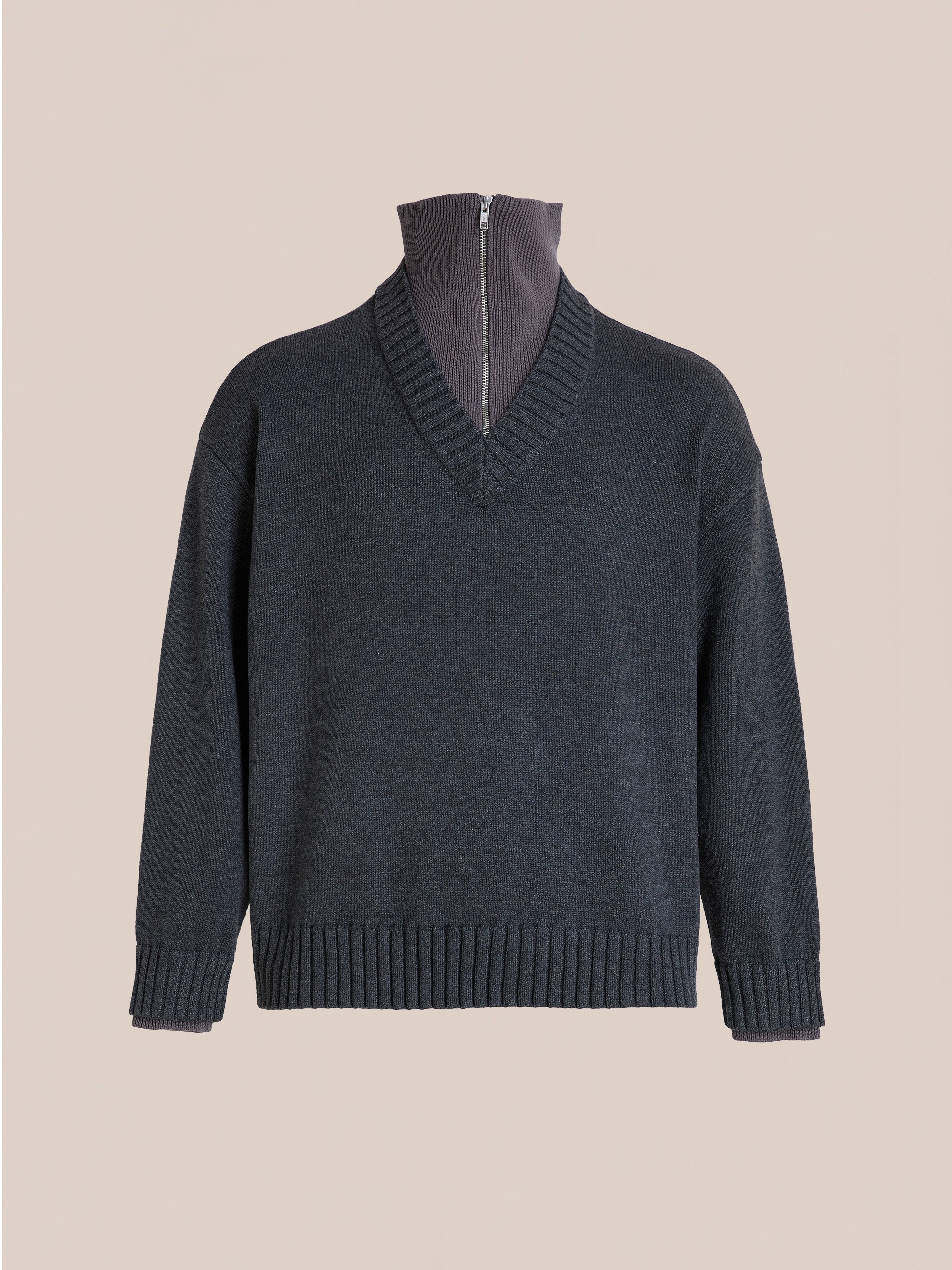 The FOUND Double Layer Sweater features a charcoal wool blend V-neck knit over a high-neck zip-up layer, showcased on a plain beige background.