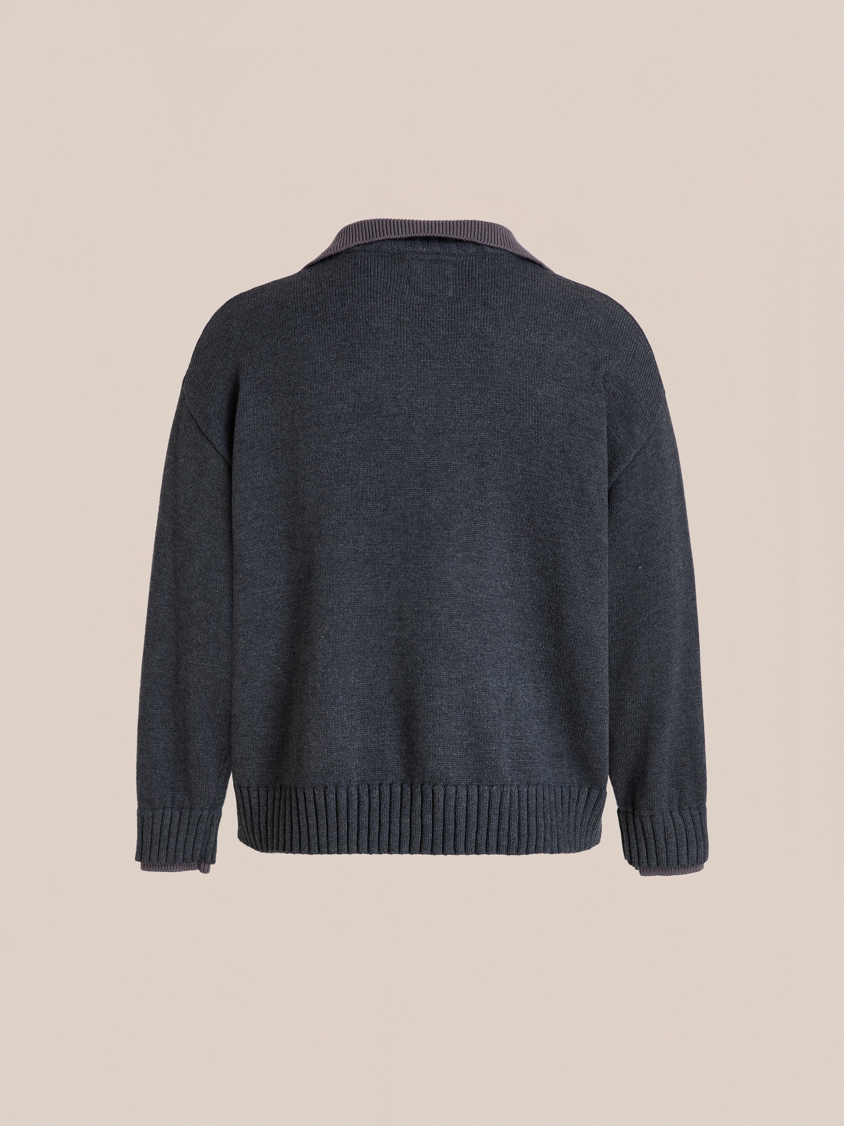 The FOUND Double Layer Sweater in charcoal wool blend is shown from the back with ribbed V-neck, cuffs, and hem, displayed on a plain beige background.
