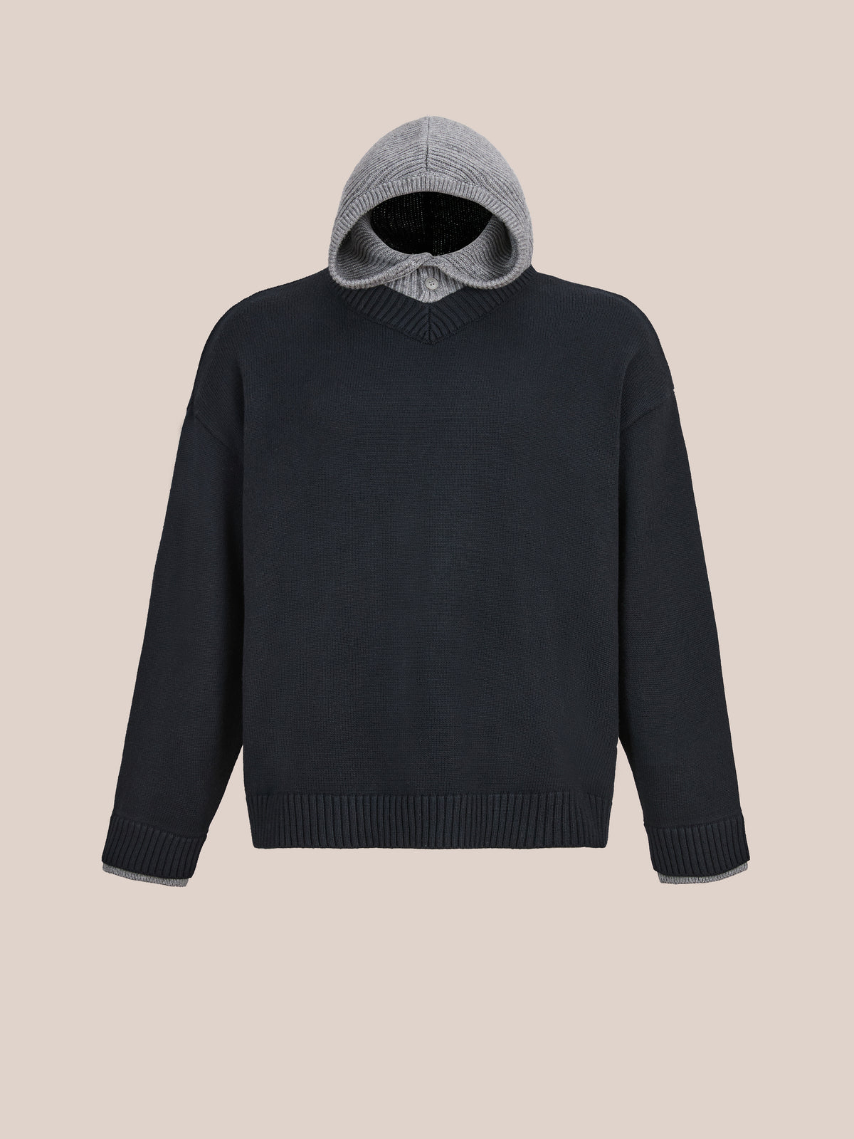 The FOUND Double Layer V Neck Knit Sweater, a unisex black knit with ribbed cuffs, hem, and an attached gray hood, is shown on a plain beige background.