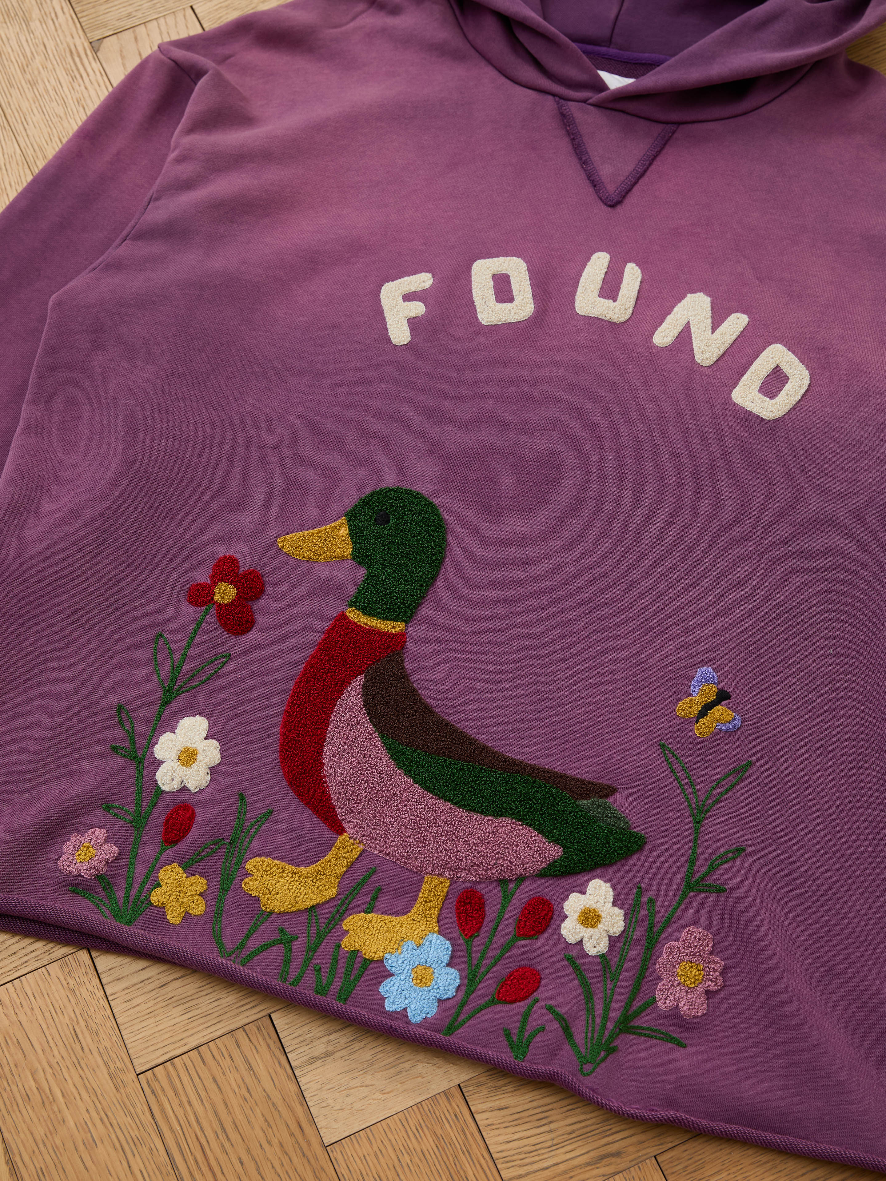 The FOUND Embroidered Wildlife Hoodie in purple features a duck, flowers, and butterfly embroidery on soft French-terry—perfect for vintage-inspired style.