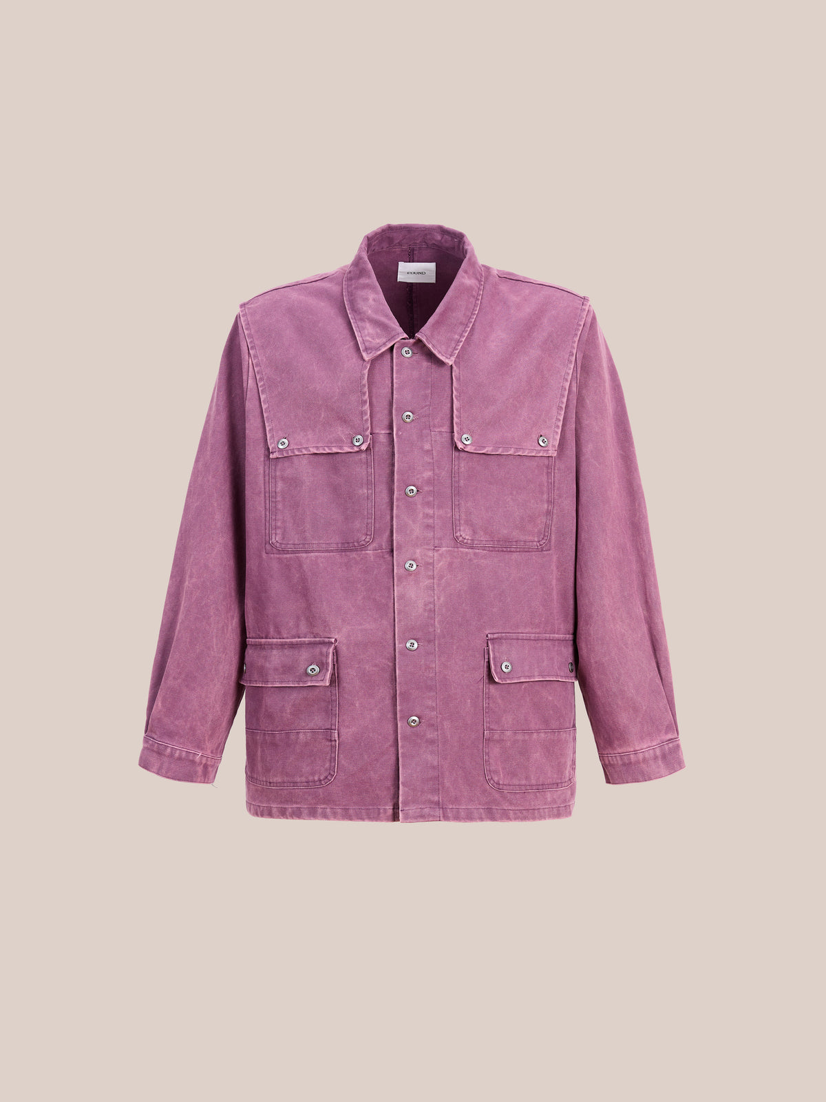The Found Faded Paneled Cargo Jacket, featuring a mauve corduroy design with large front pockets and snap buttons, is showcased against a plain beige background.