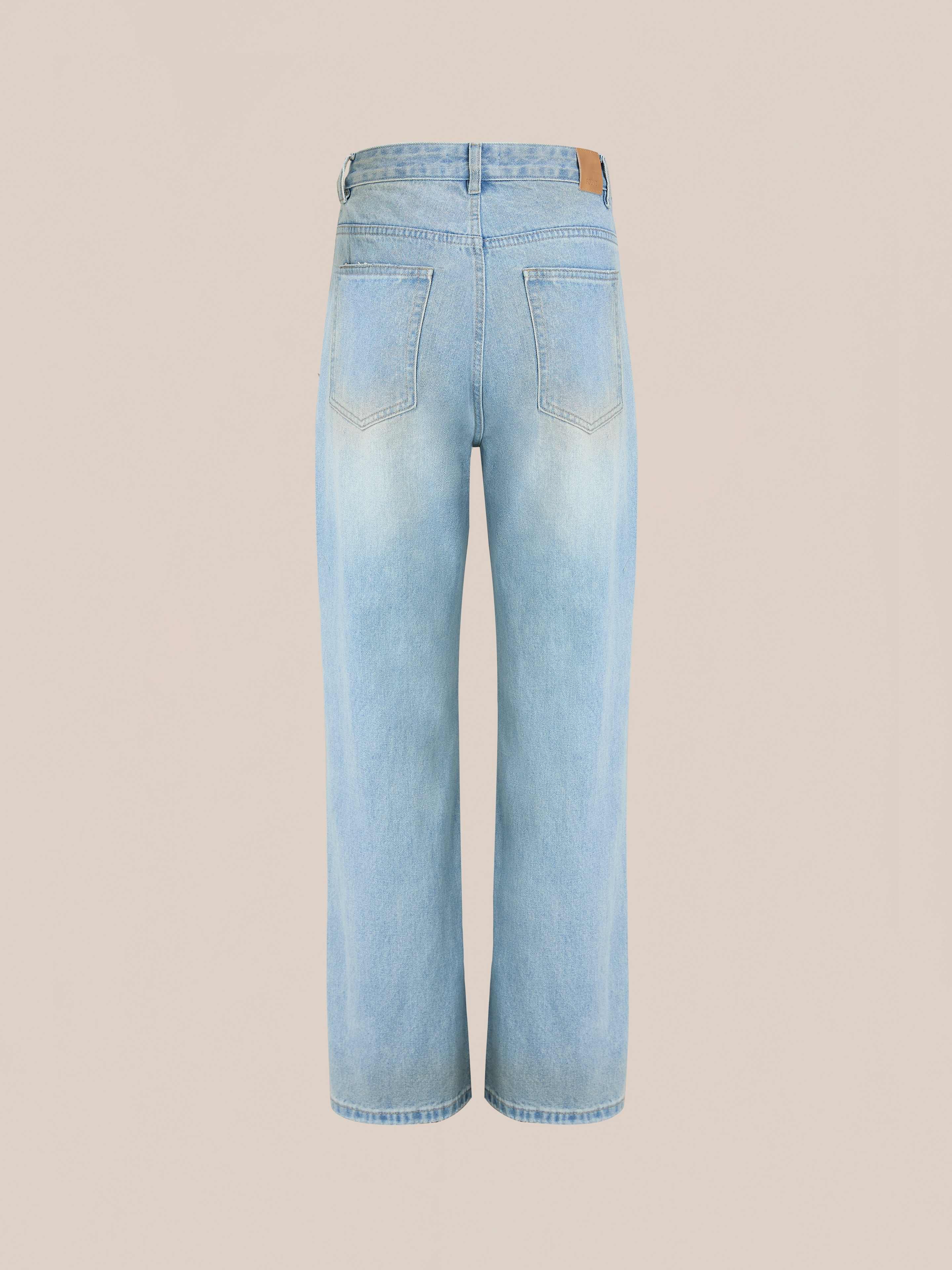 The Found Flare Jeans in light blue denim are shown from the back with two back pockets, distressed hems, and a wide-leg cut, displayed against a plain beige background.