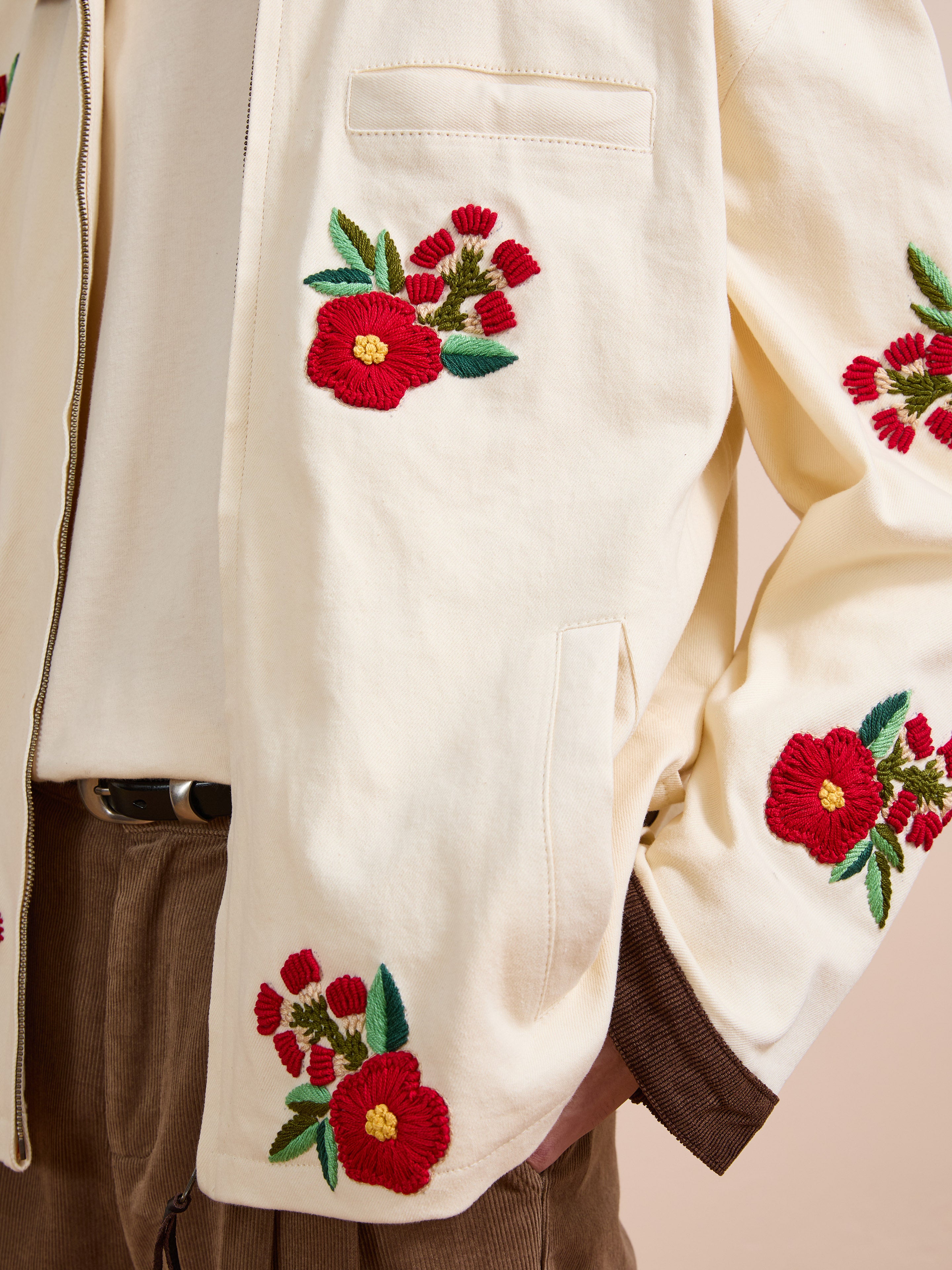 A person wearing Found’s Floral Hand Embroidered Work Jacket, inspired by vintage South Asian needlework, styled with brown corduroy pants and a white shirt.