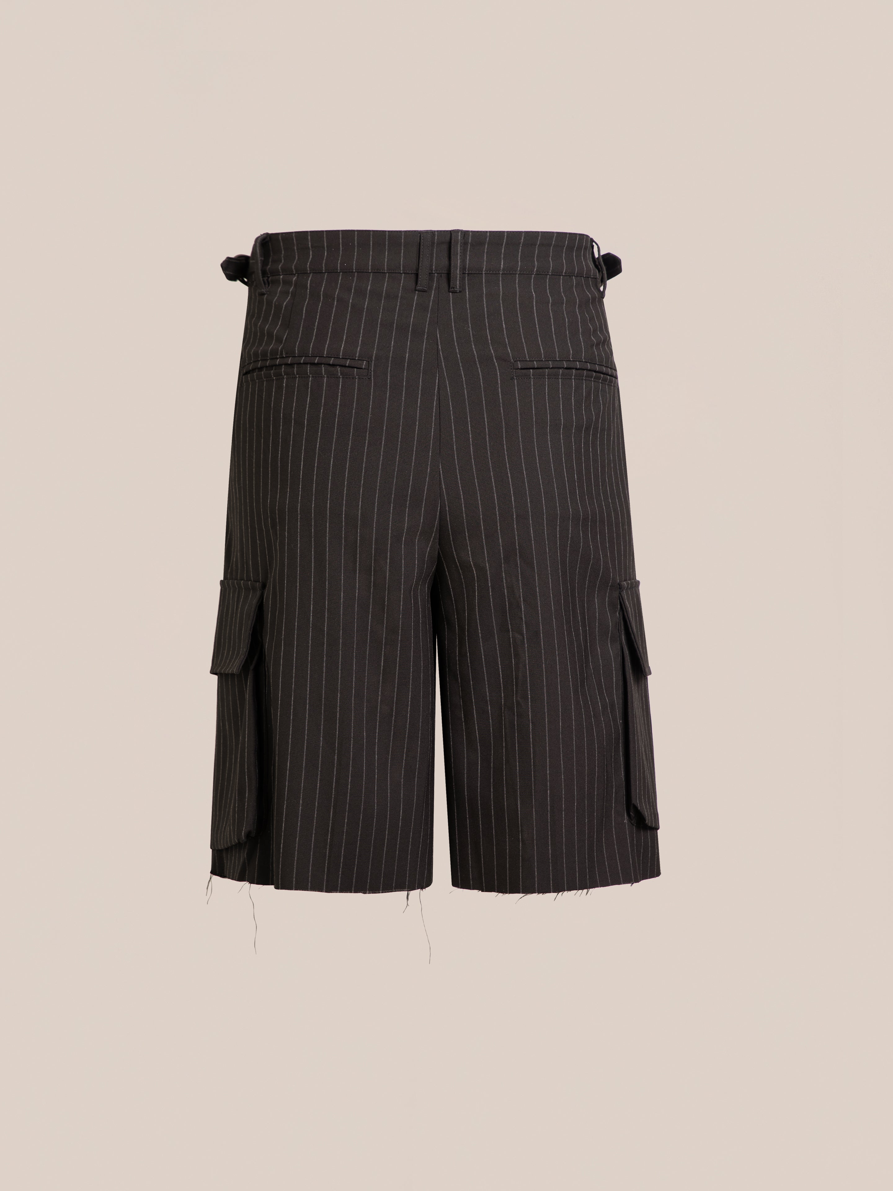 The FOUND Hava Pinstripe Pleated Cargo Trouser Shorts feature side pockets, raw hems, and an adjustable unisex fit. Shown against a plain beige background.