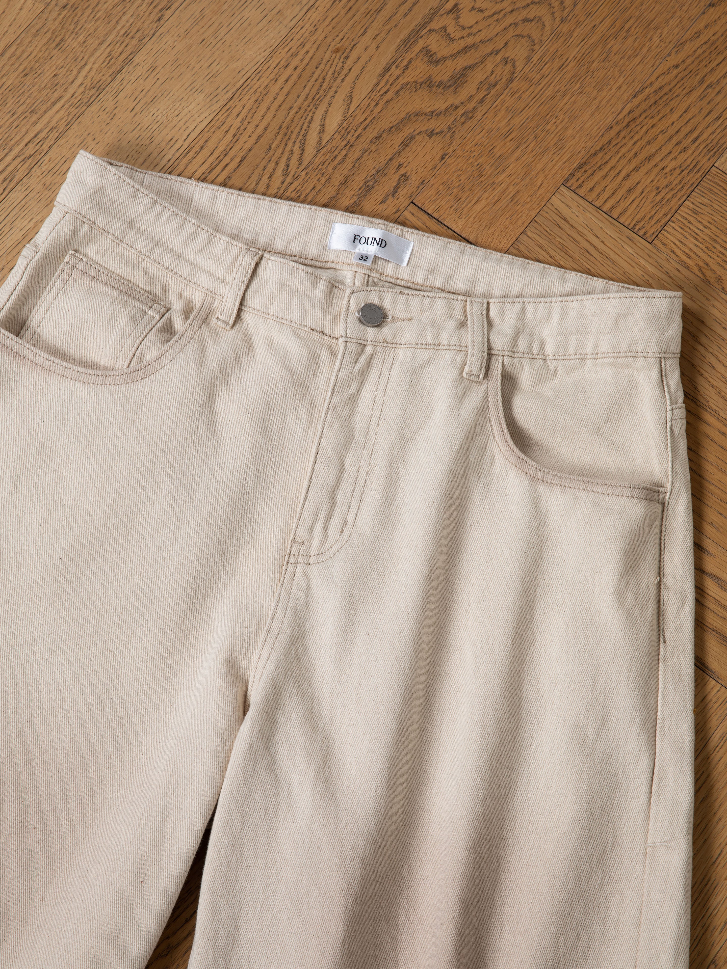 The FOUND Lacy Jean Jorts are distressed denim shorts with front pockets and a button closure, shown laid flat on a wooden floor.