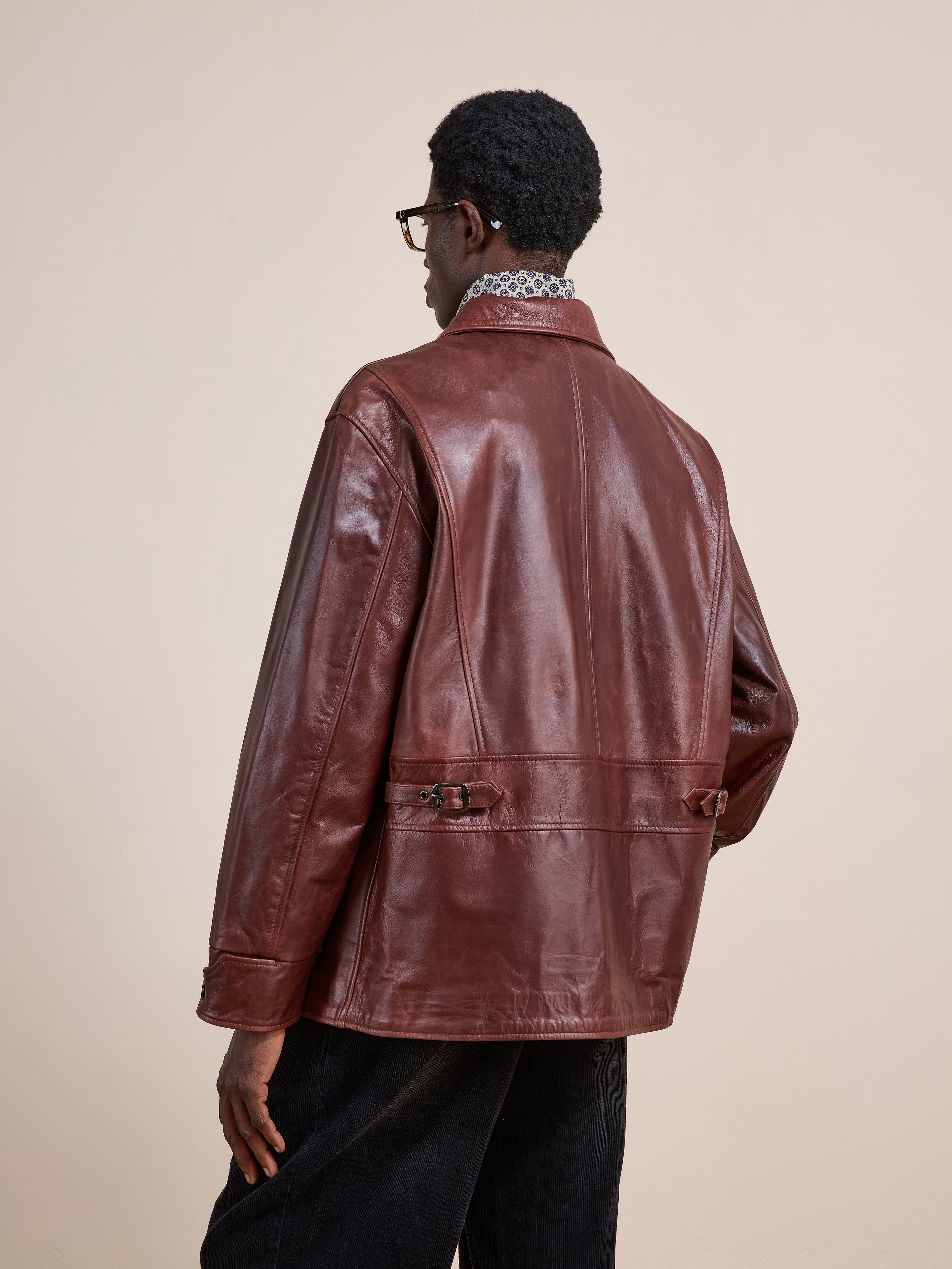 A person wearing the FOUND Leather Field Jacket and black pants stands with their back to the camera against a plain, light-colored background.