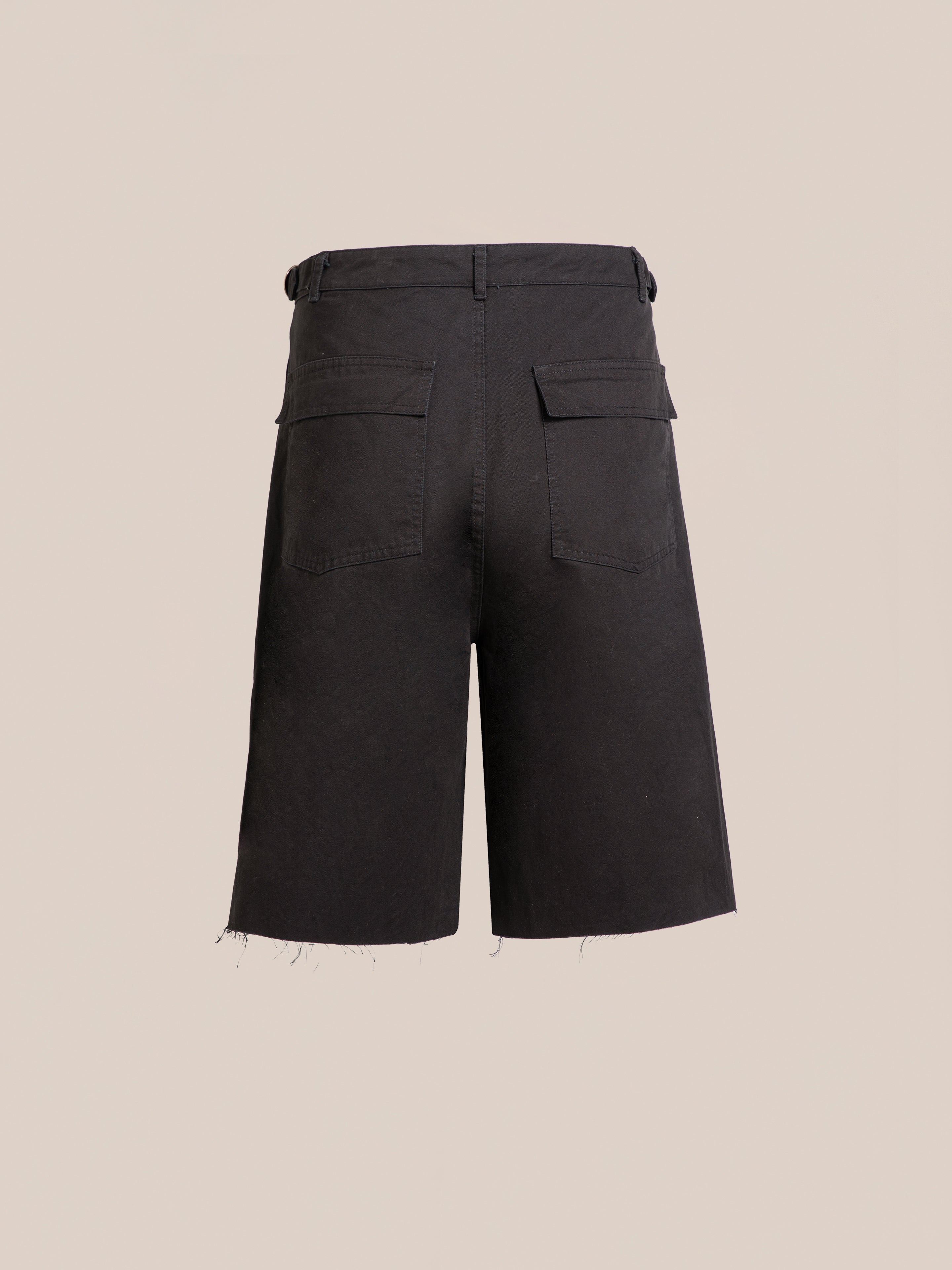 Found Parachute Cargo Twill Shorts in black, shown from the back with two pockets, belt loops, and raw hems against a beige background—exuding a laid-back utility style.