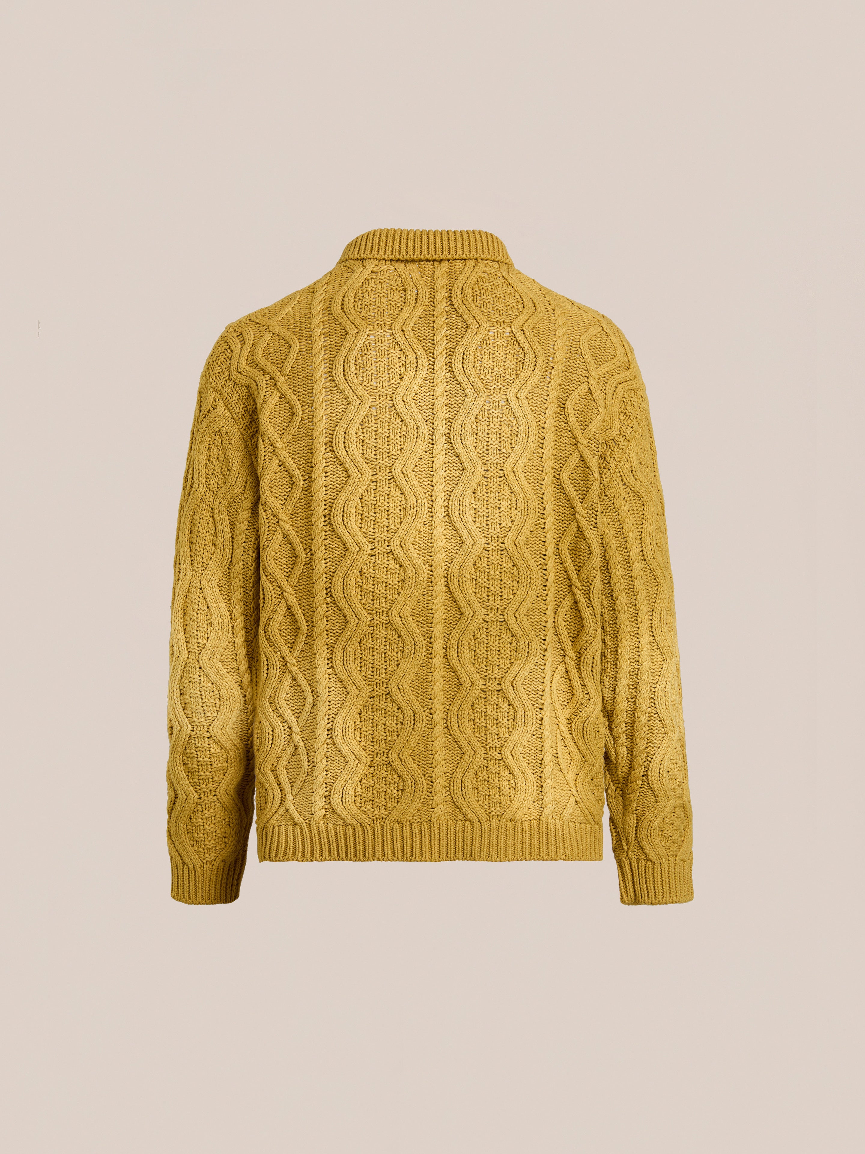 The FOUND Cable Knit Buttoned Cardigan in mustard yellow is shown from the back, featuring chunky cable knitting against a plain beige background.