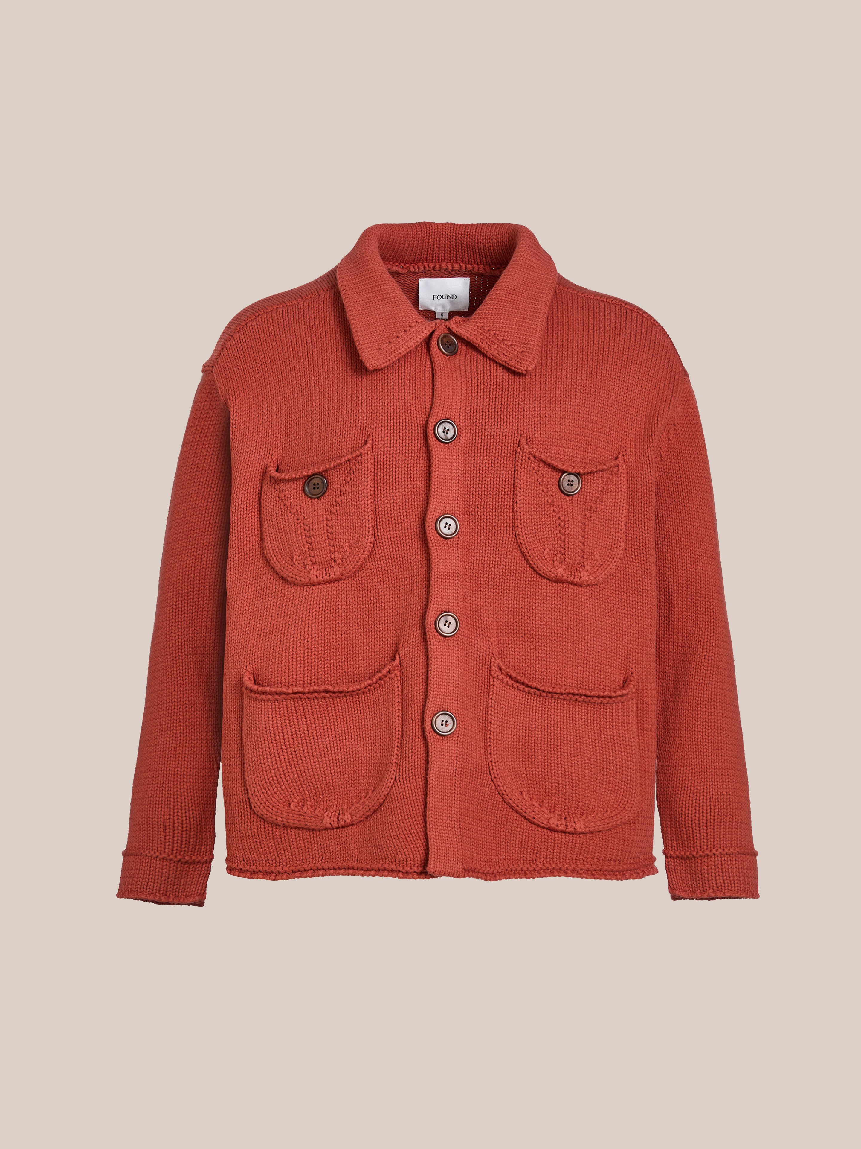 The Hunter Knit Collared Cardigan by FOUND is a rust-colored sweater featuring a collared neckline, four button-closure front pockets, and crafted from heavy knit cotton, ideal for transitional layering.