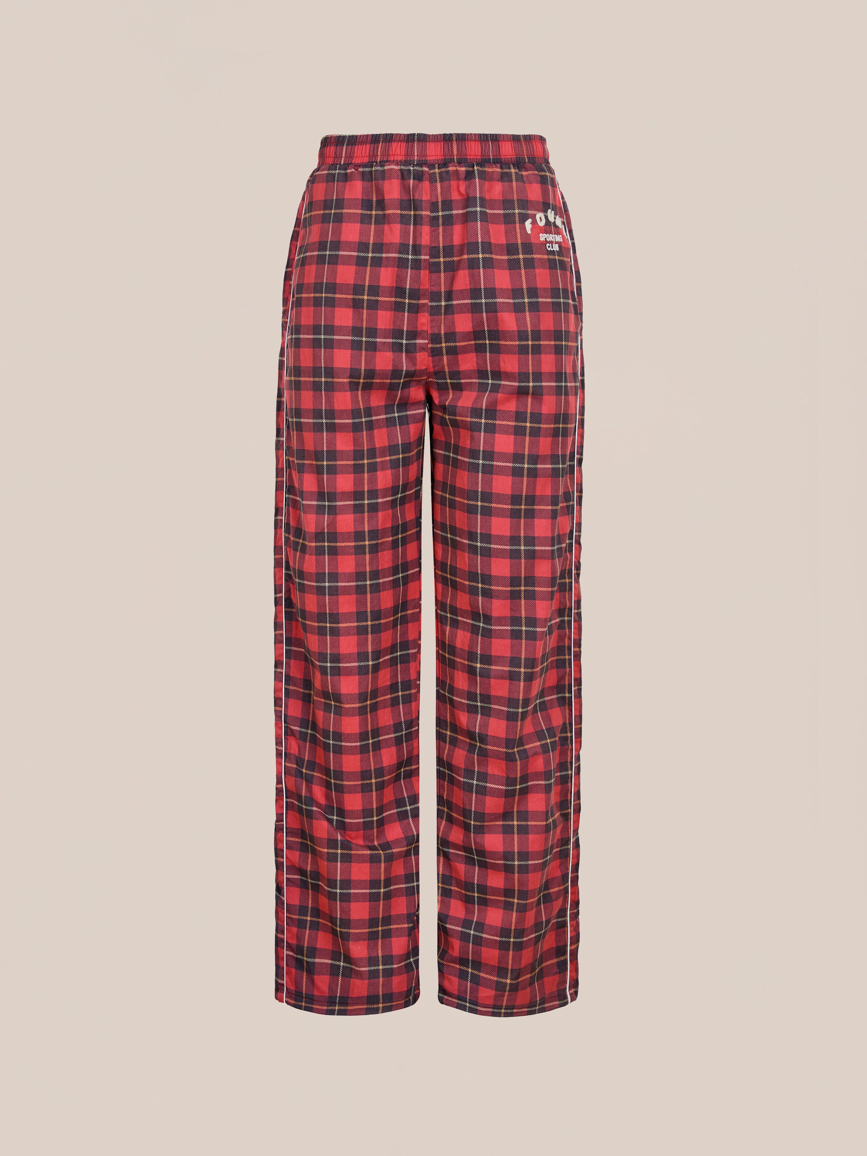 Found Red Plaid Track Pants feature an elastic waistband, side pockets, and a relaxed fit for pajama-like comfort with sporty style. Displayed against a plain light background.
