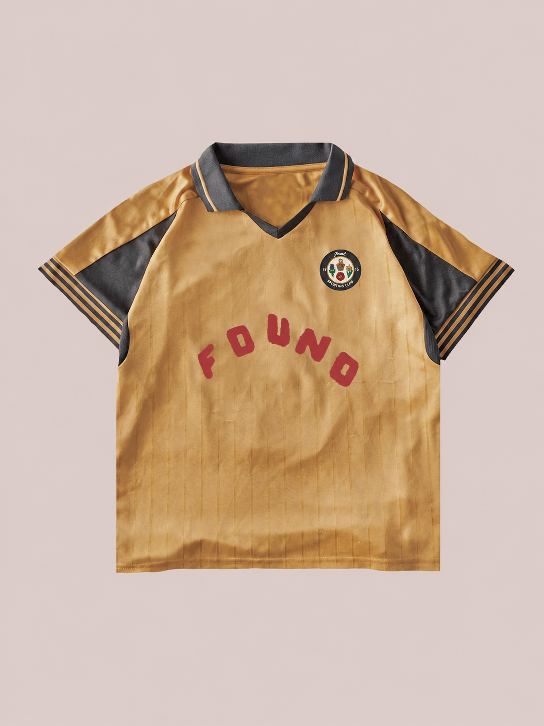 The Rosewood Jersey by FOUND is a golden unisex vintage football top with black collar and trim, red "FOUND" lettering on the front, and a chest circular patch—an iconic piece of sportswear.
