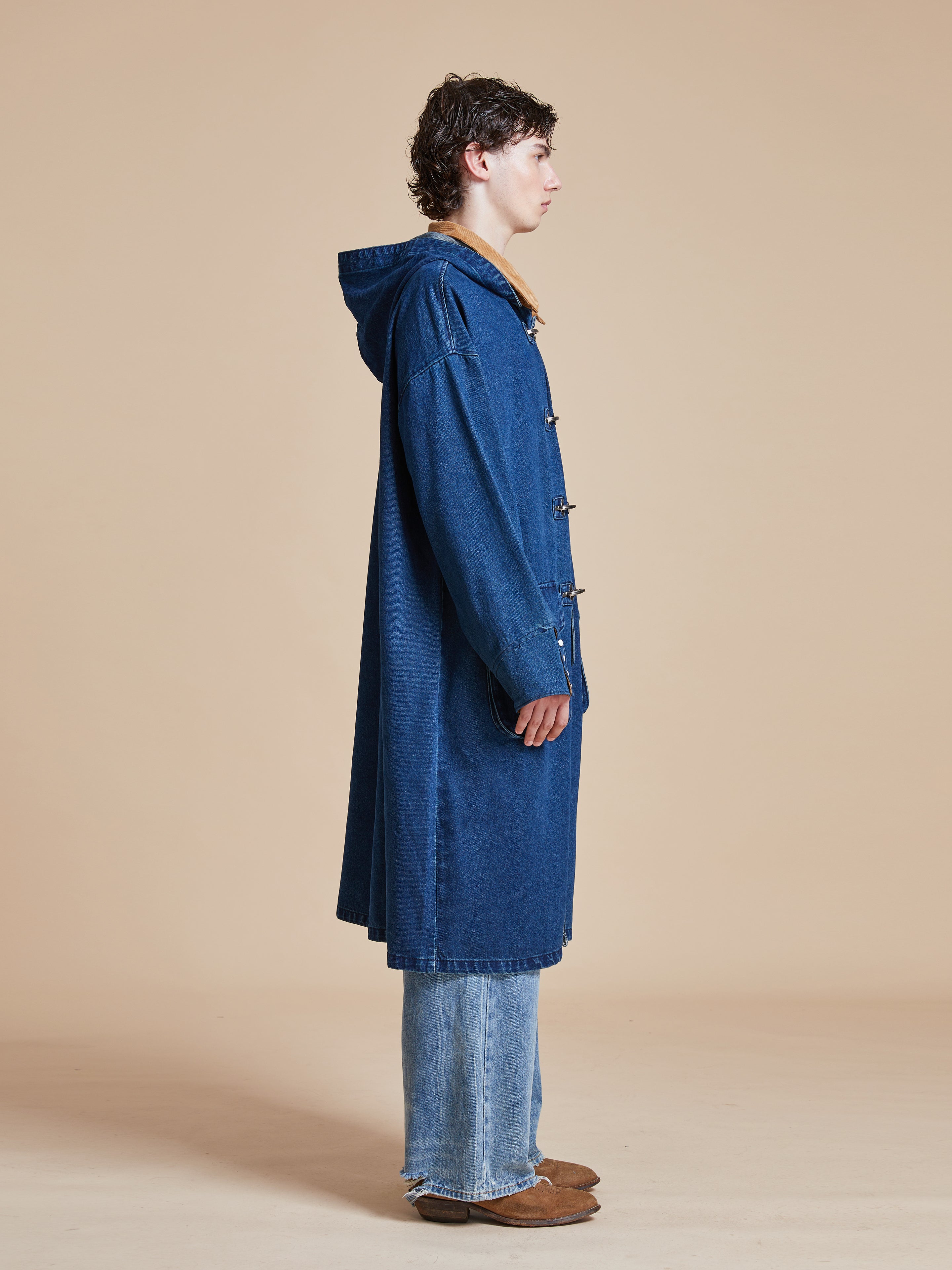 A man in a Found Sargasso Denim Buckle Coat.