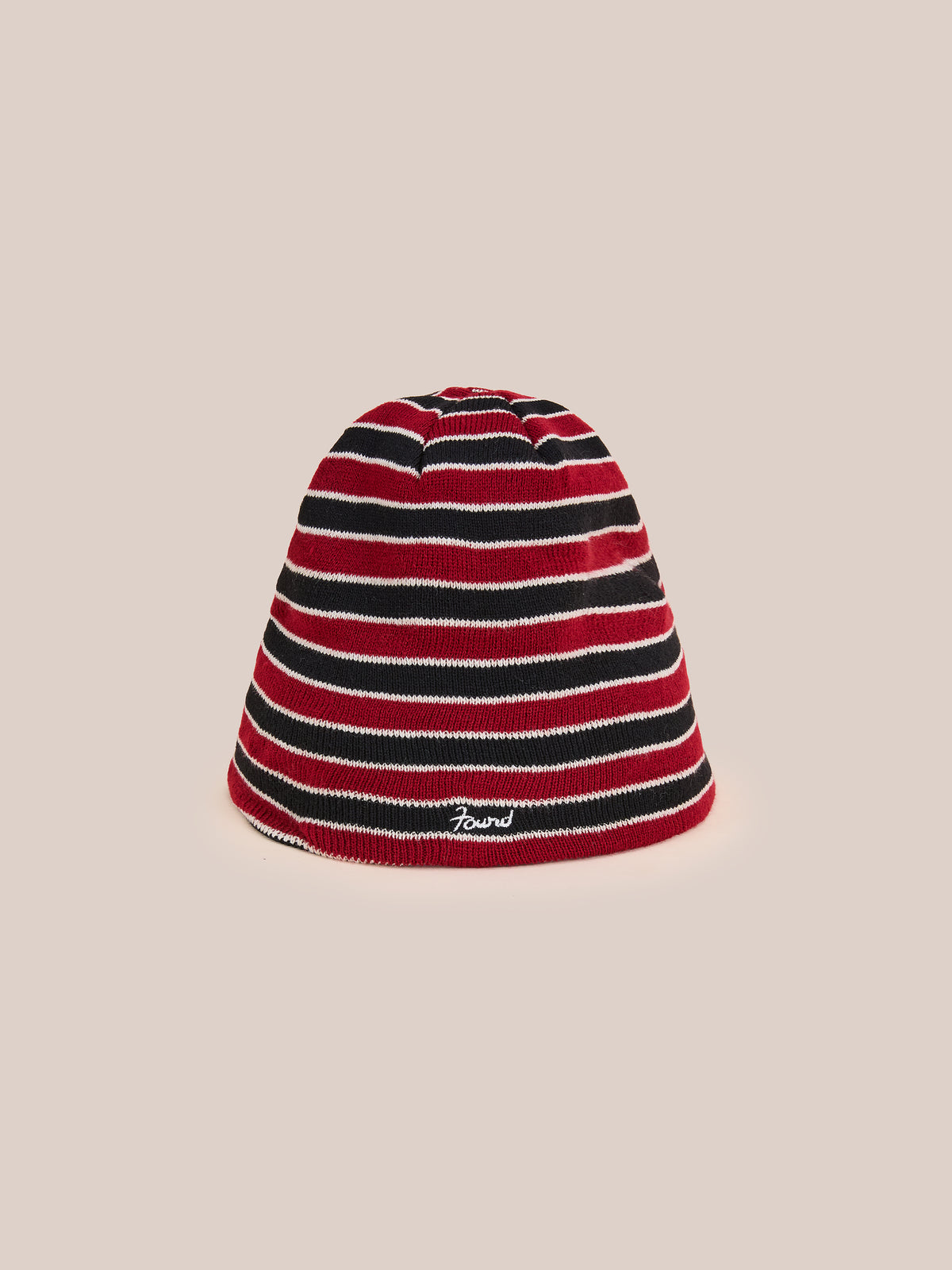 Stripe Logo Beanie by FOUND in red and black with a small FOUND logo on front, displayed on a beige background.