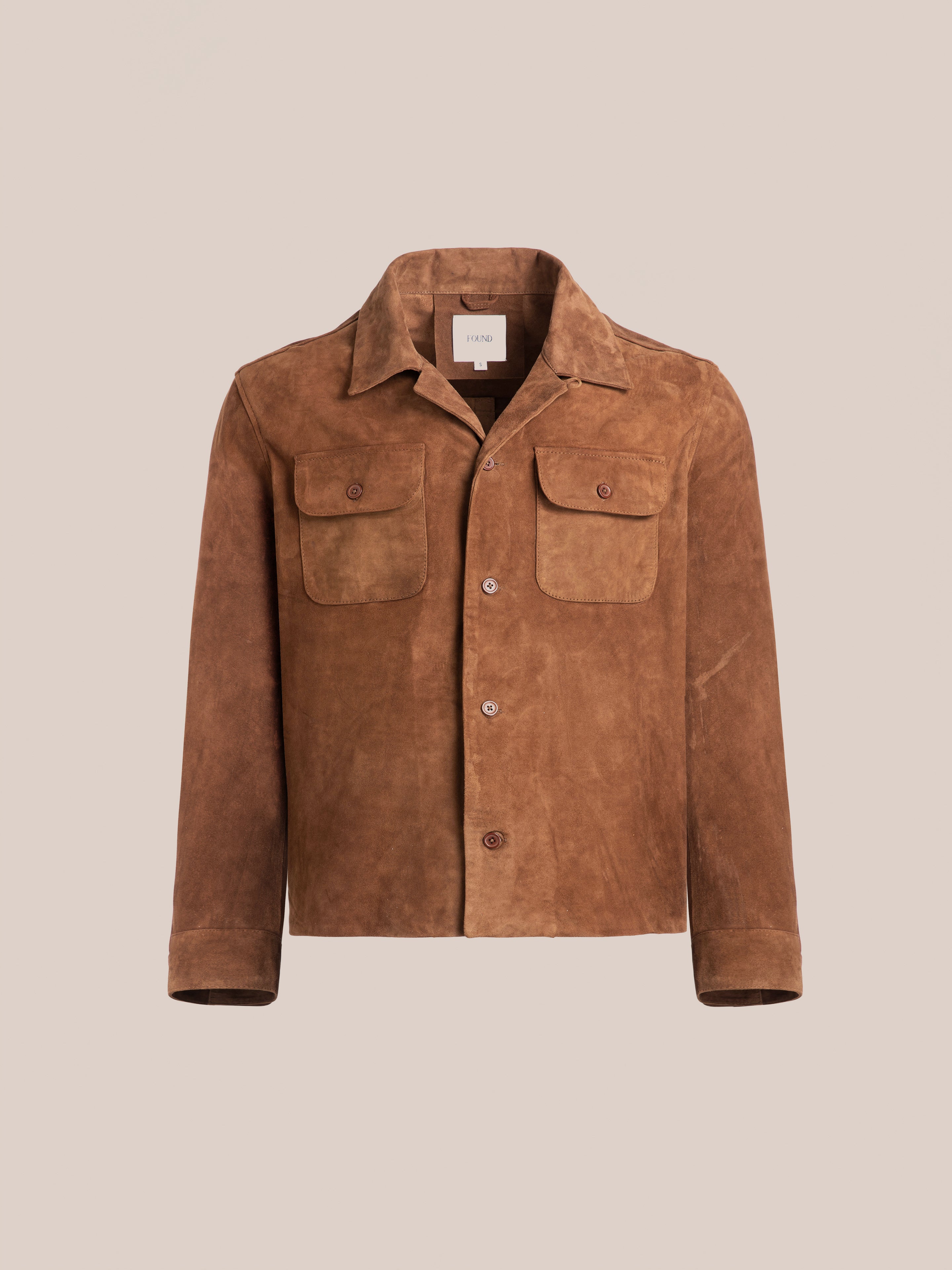 FOUND Suede Leather Camp Shirt in brown goat suede features a collar, button front, two chest flap pockets, and long sleeves in a unisex relaxed fit, shown against a plain light background.