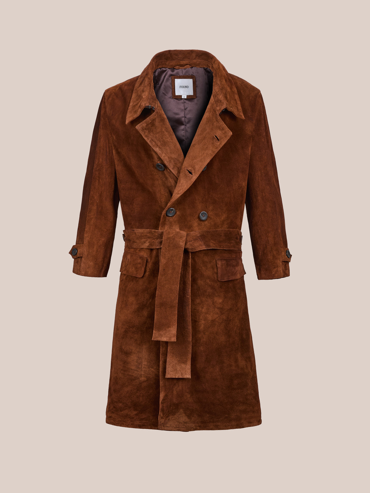 The FOUND Belted Suede Trench Coat features wide lapels, front buttons, and flap pockets—a timeless unisex style shown against a plain beige background.