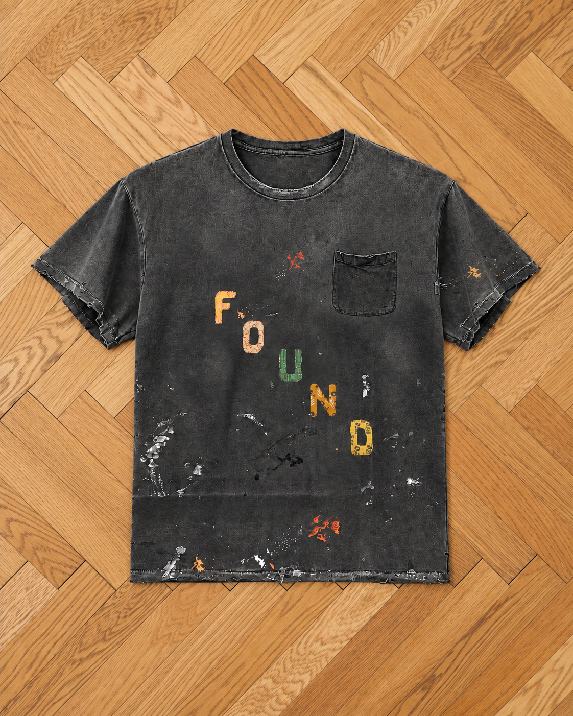 The FOUND Tapestry Logo Paint Tee is a black, distressed unisex relaxed fit tee with a chest pocket and colorful “FOUND” lettering on the front.