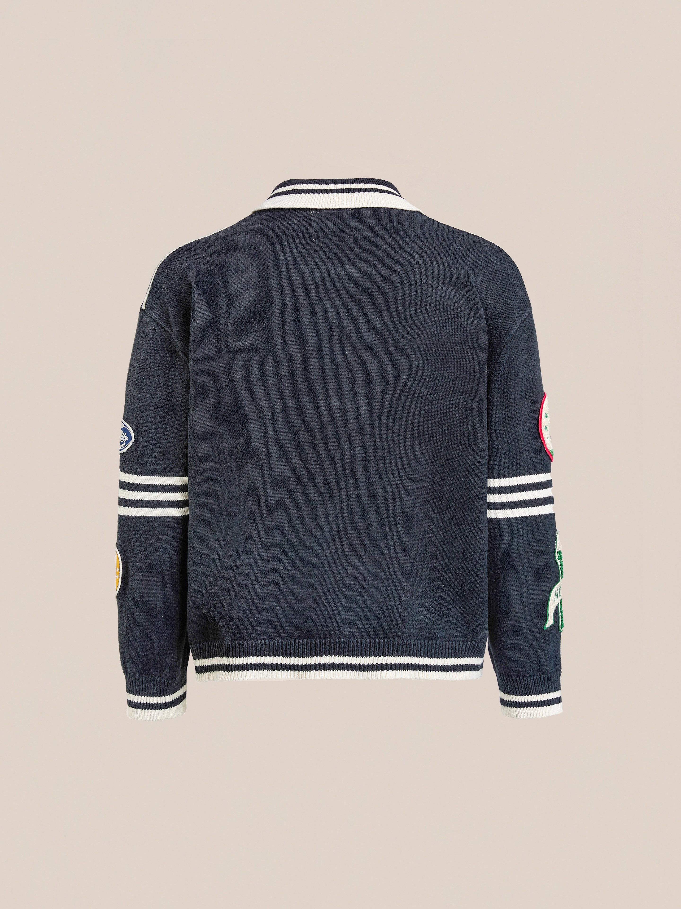 The FOUND Varsity Patch Collared Cardigan is a navy cotton knit with white striped cuffs and collar, plus chenille patch embroidery on the sleeves, shown from the back.