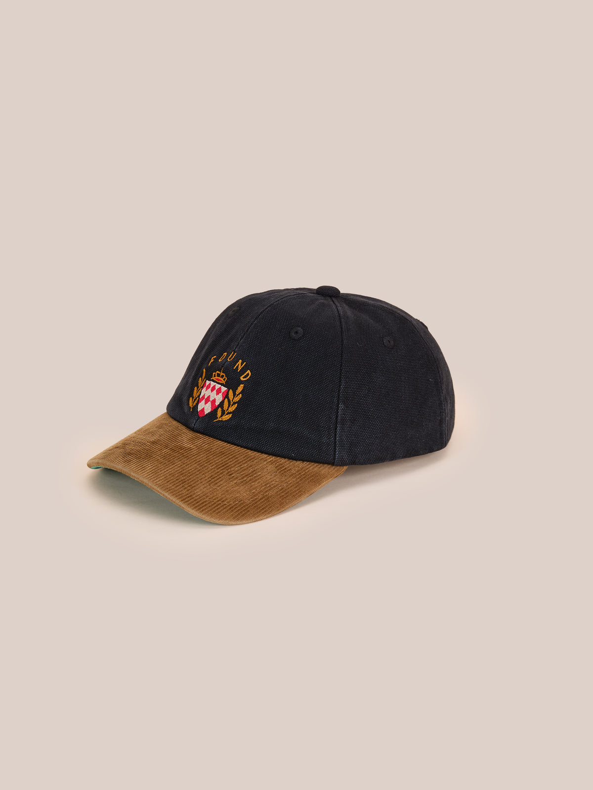 Found Vintage Club Cap in black with a brown corduroy brim, embroidered crest, and vintage details, shown on a light beige background.