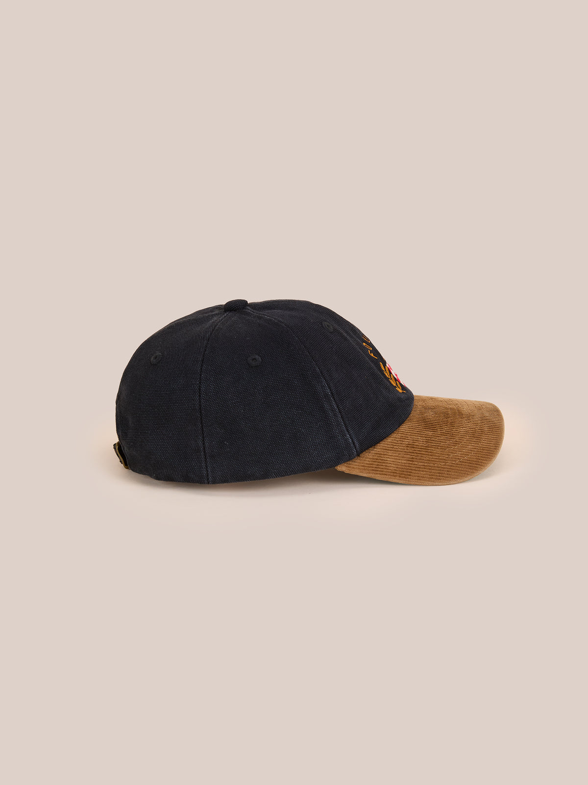 A Found Vintage Club Cap in black with a brown corduroy brim and vintage details is shown from the side on a plain beige background.