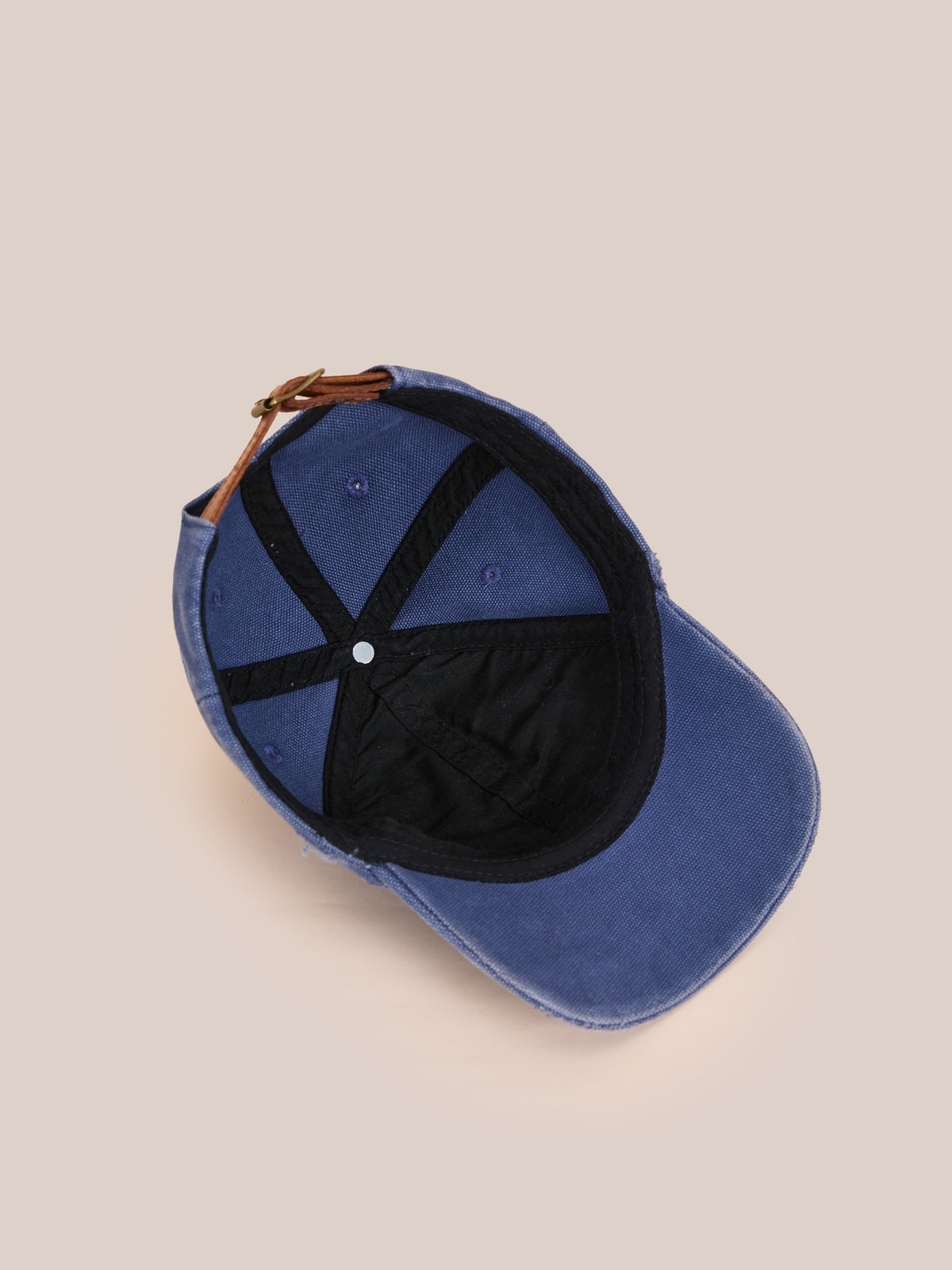 The Vintage Club Cap by Found in blue features black interior lining, visible stitching, and an adjustable leather strap at the back.
