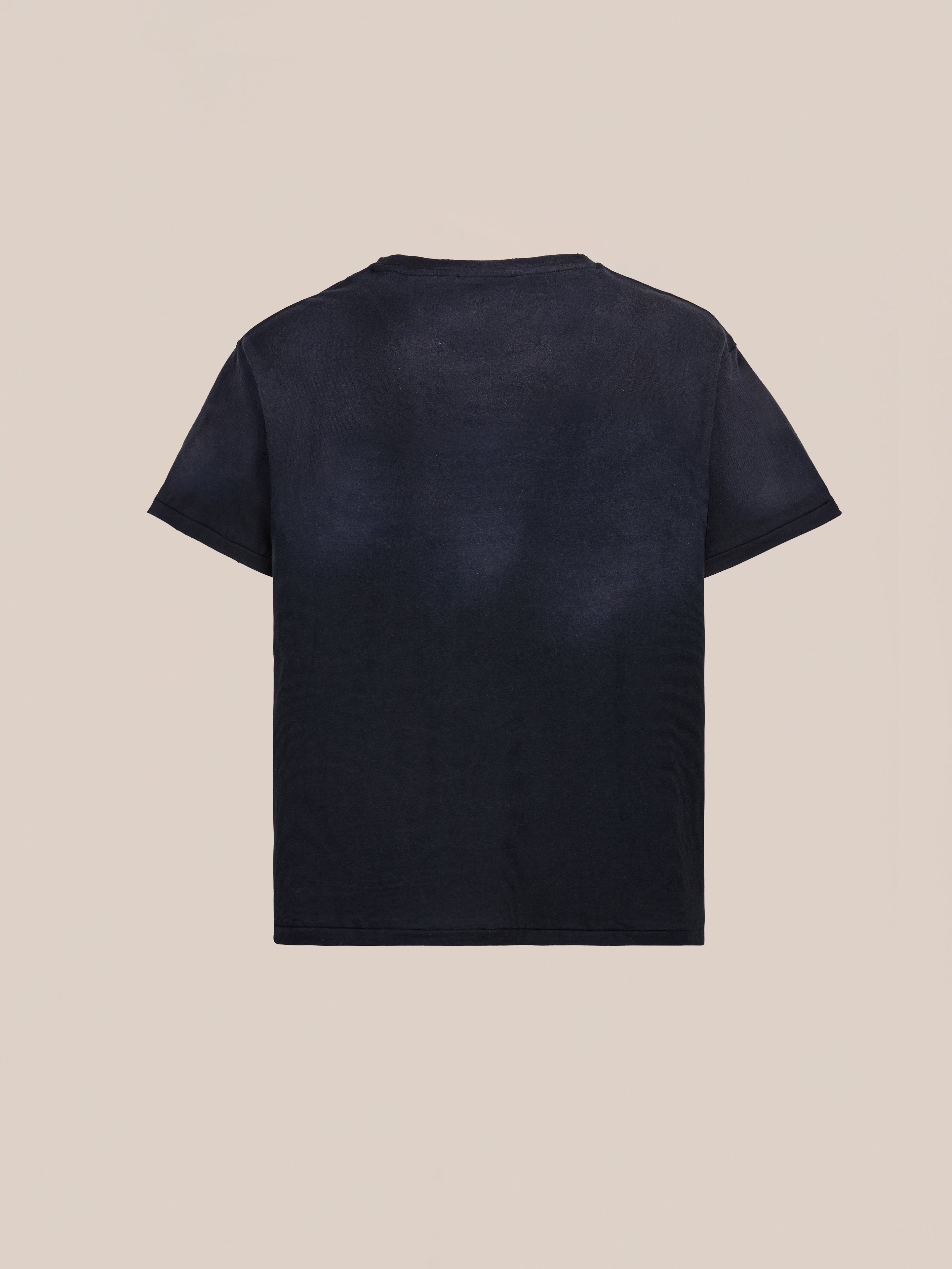 The FOUND Weathered Pocket Tee, a unisex relaxed-fit short-sleeve t-shirt in plain black, is displayed from the back on a light beige background.