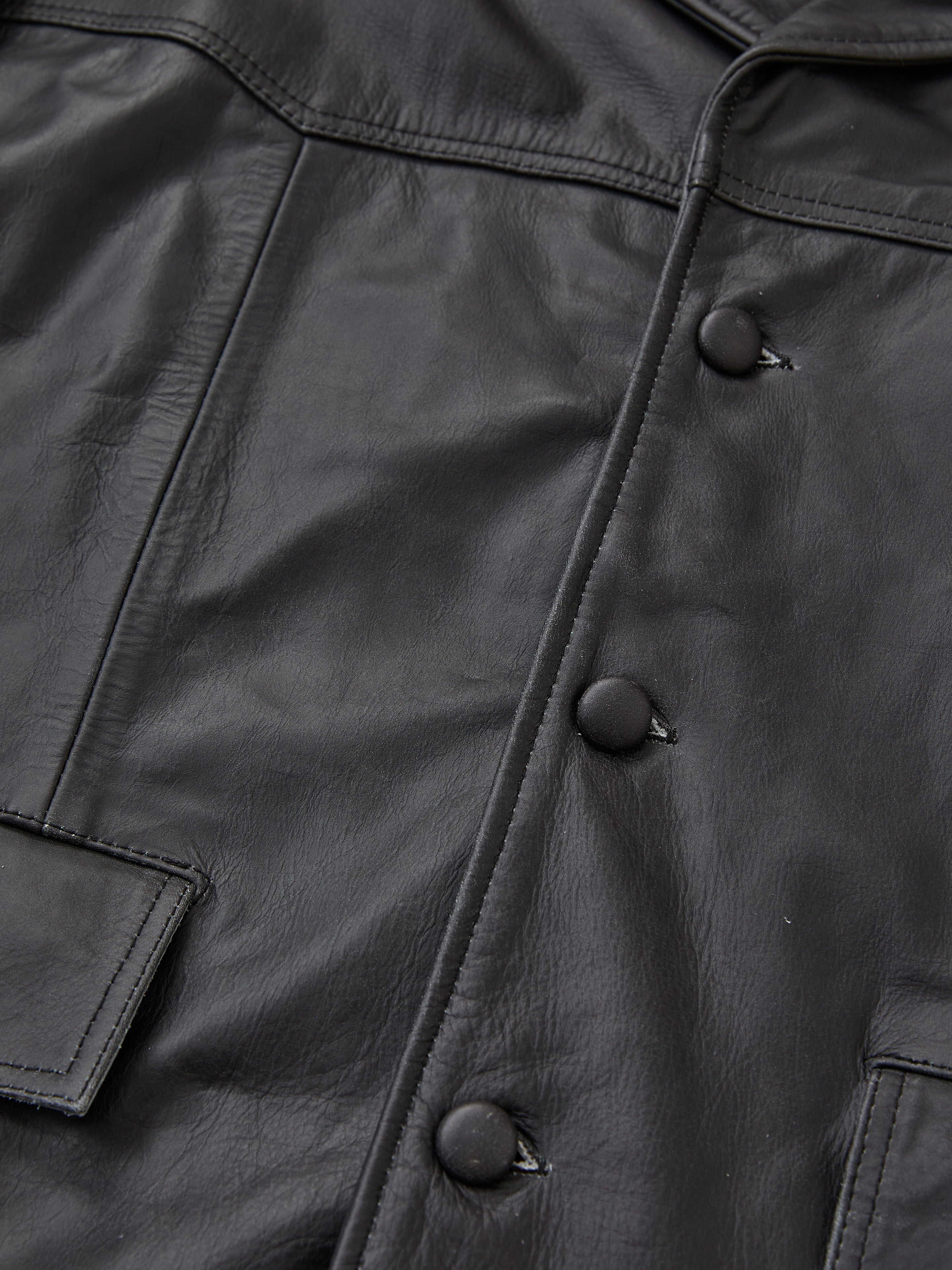 Close-up of the FOUND Western Oversized Leather Blazer, showcasing matte black snap buttons, a flap pocket, and visible stitching details.