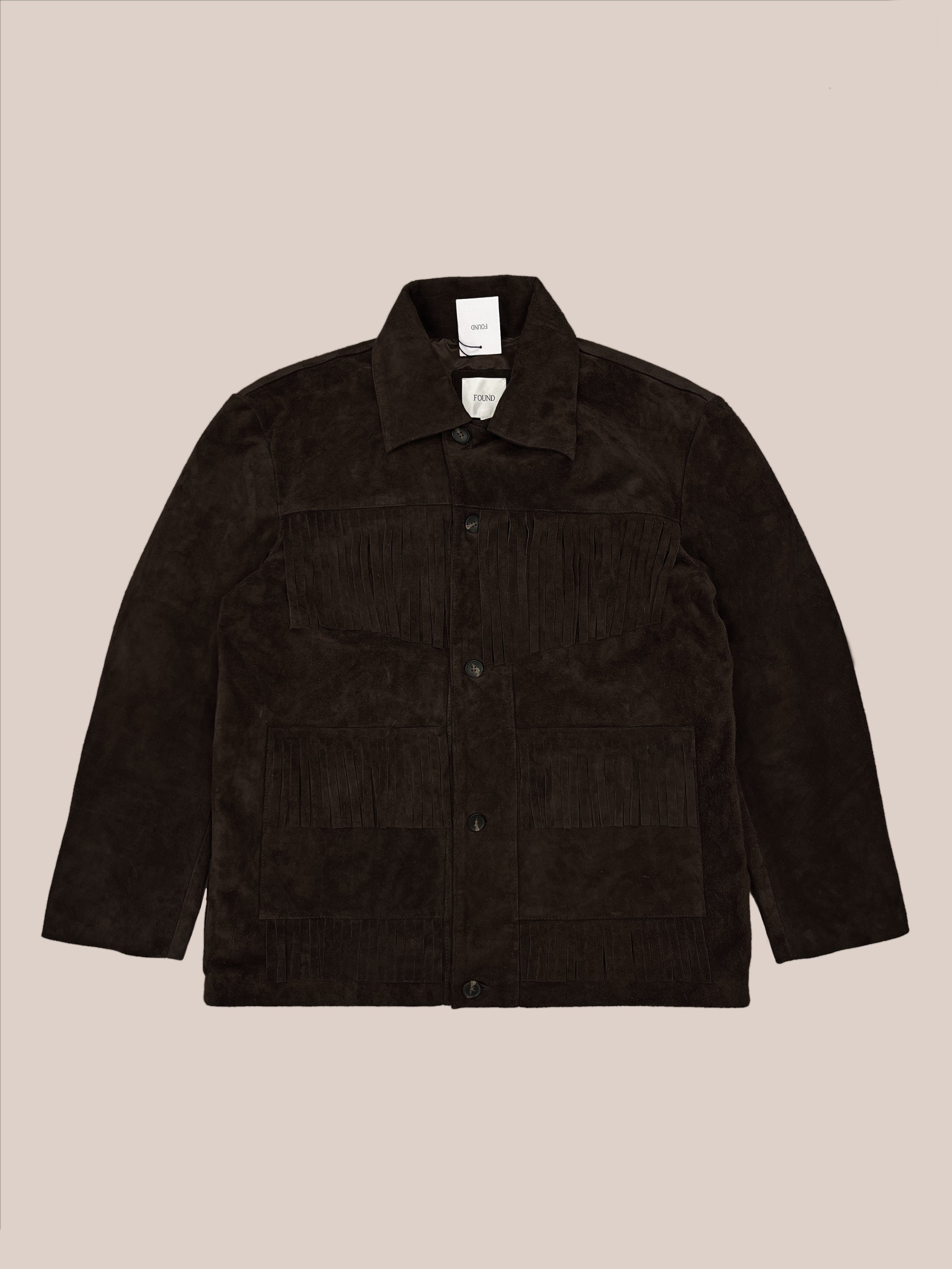 The FOUND Western Suede Fringe Jacket features a button front, two large front pockets, and fringe detailing on the chest and pockets, shown on a neutral background.