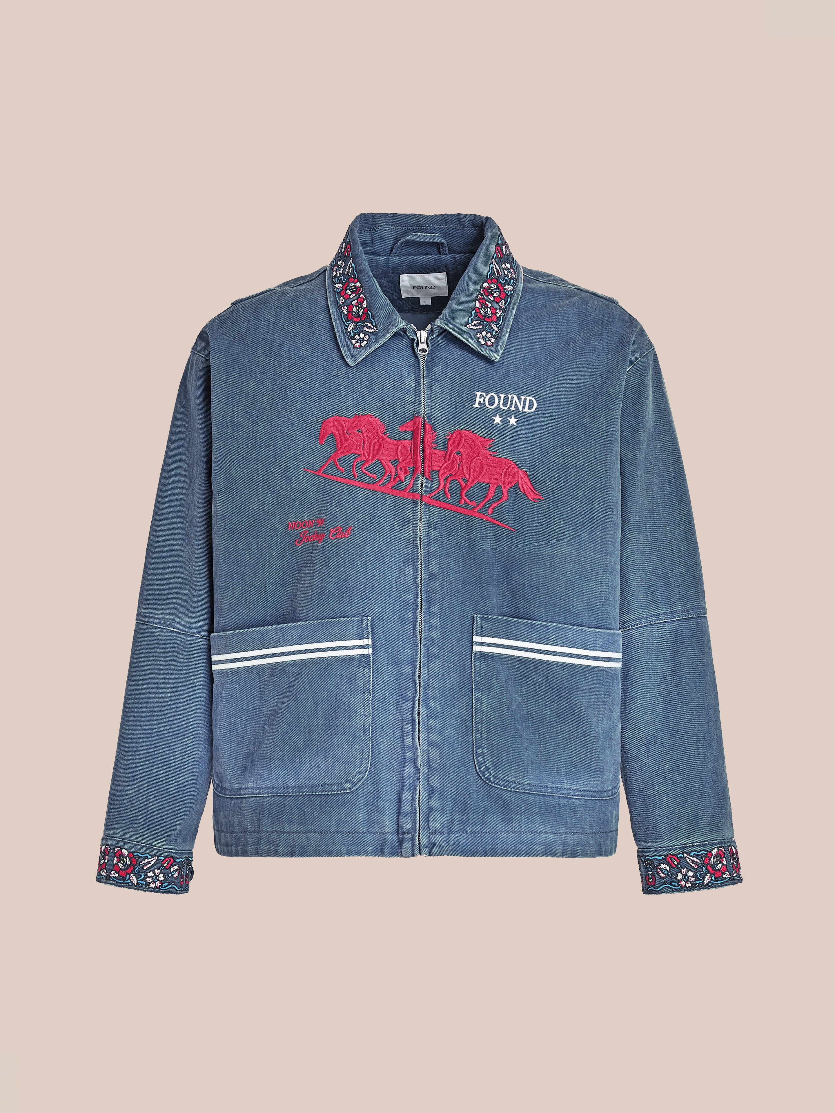 The Jockey Club Embroidered Jacket by Found is a blue denim, unisex relaxed-fit zip-up featuring floral embroidery on the collar and cuffs, two white-striped pockets, plus a red horse graphic and "FOUND" text on the chest.