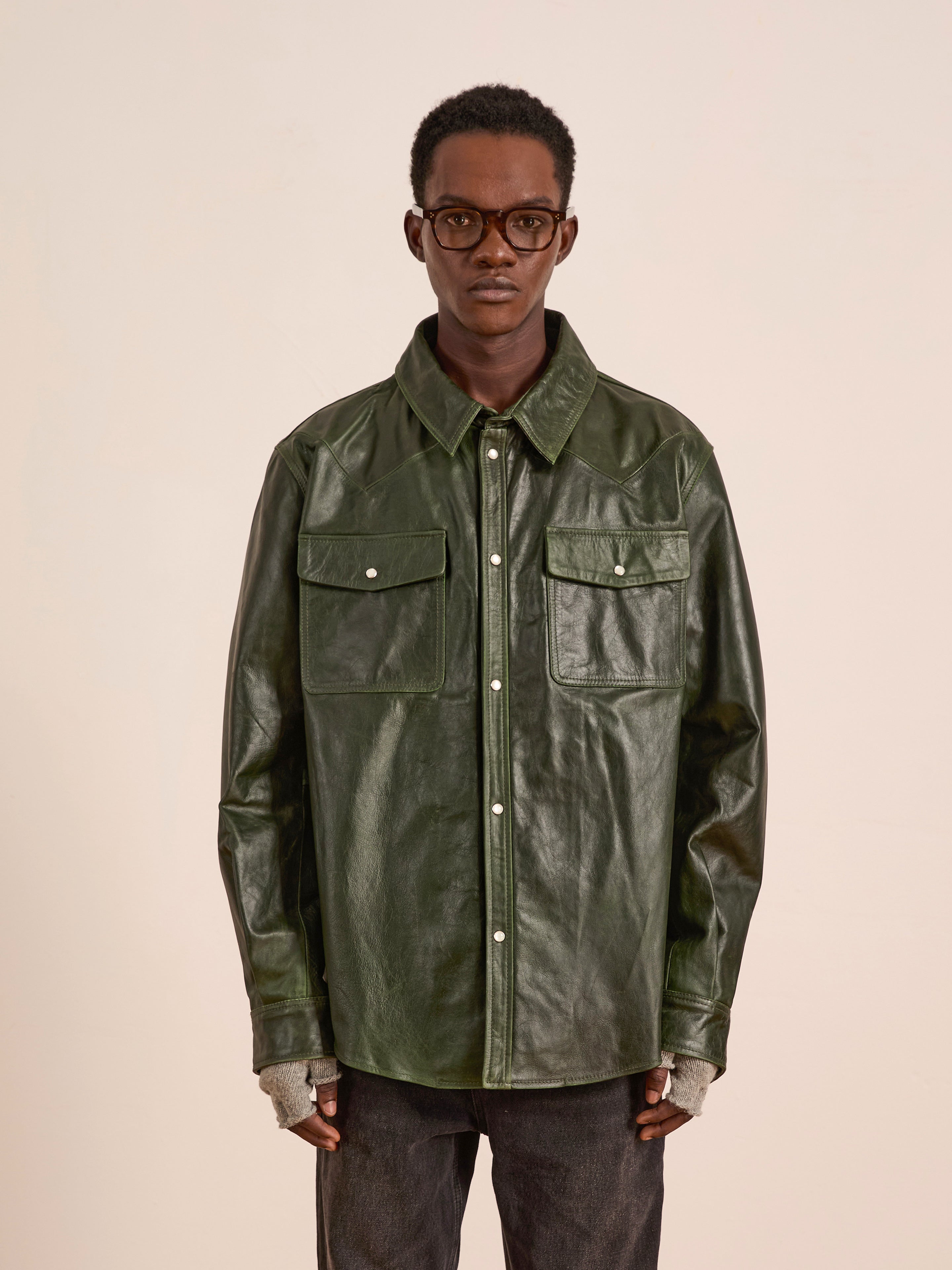 A person wearing glasses and the FOUND Forest Leather Western Shirt stands against a plain light background.