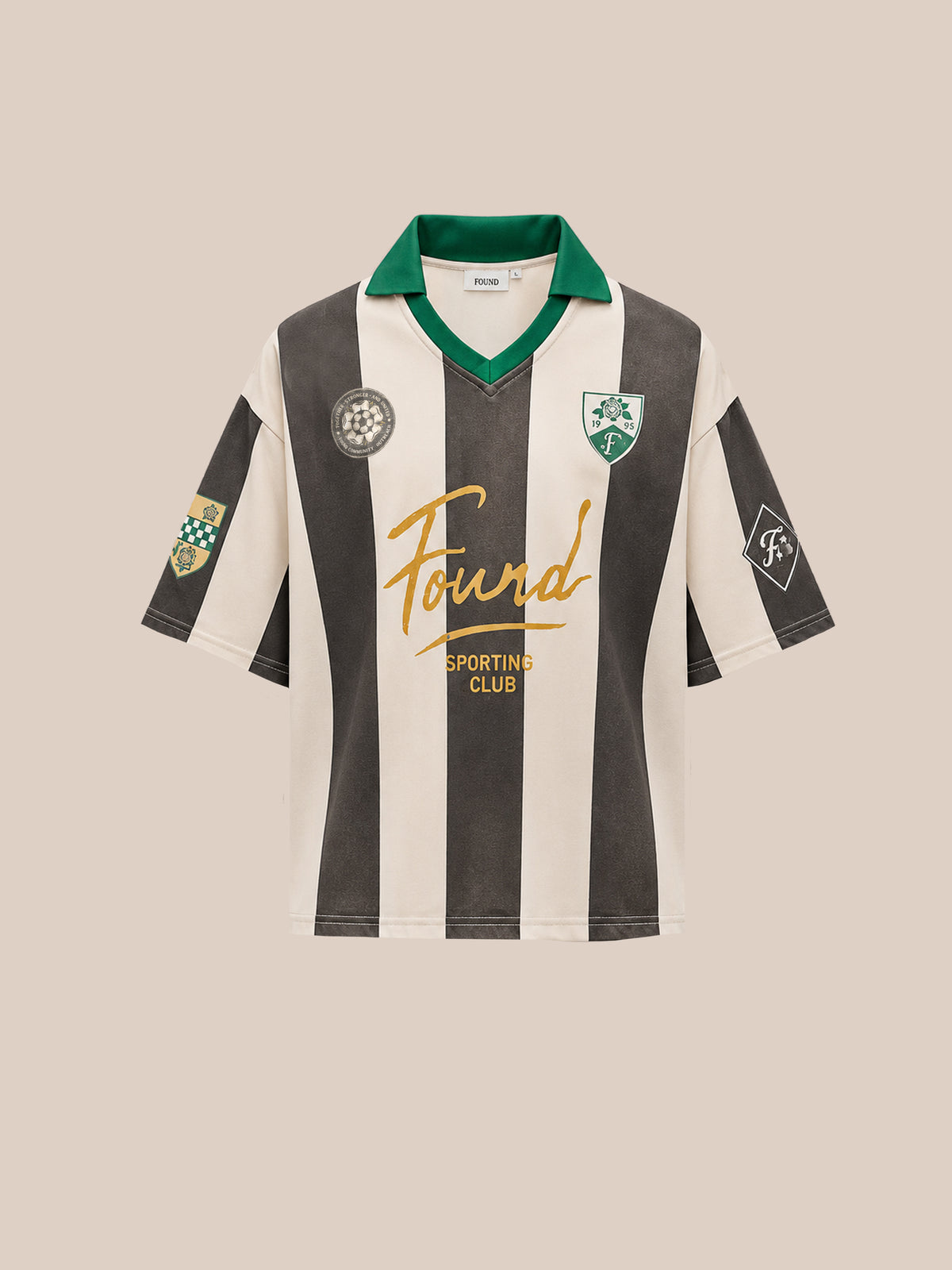Introducing the FOUND Found Club Short Sleeve Jersey—a unisex black and white striped football shirt featuring a distinctive green collar, gold “Found” lettering, and an array of club and sponsor patches on the chest and sleeves. This vintage-inspired piece from FOUND seamlessly fuses classic style with modern appeal, making it an ideal choice for fans and collectors alike.