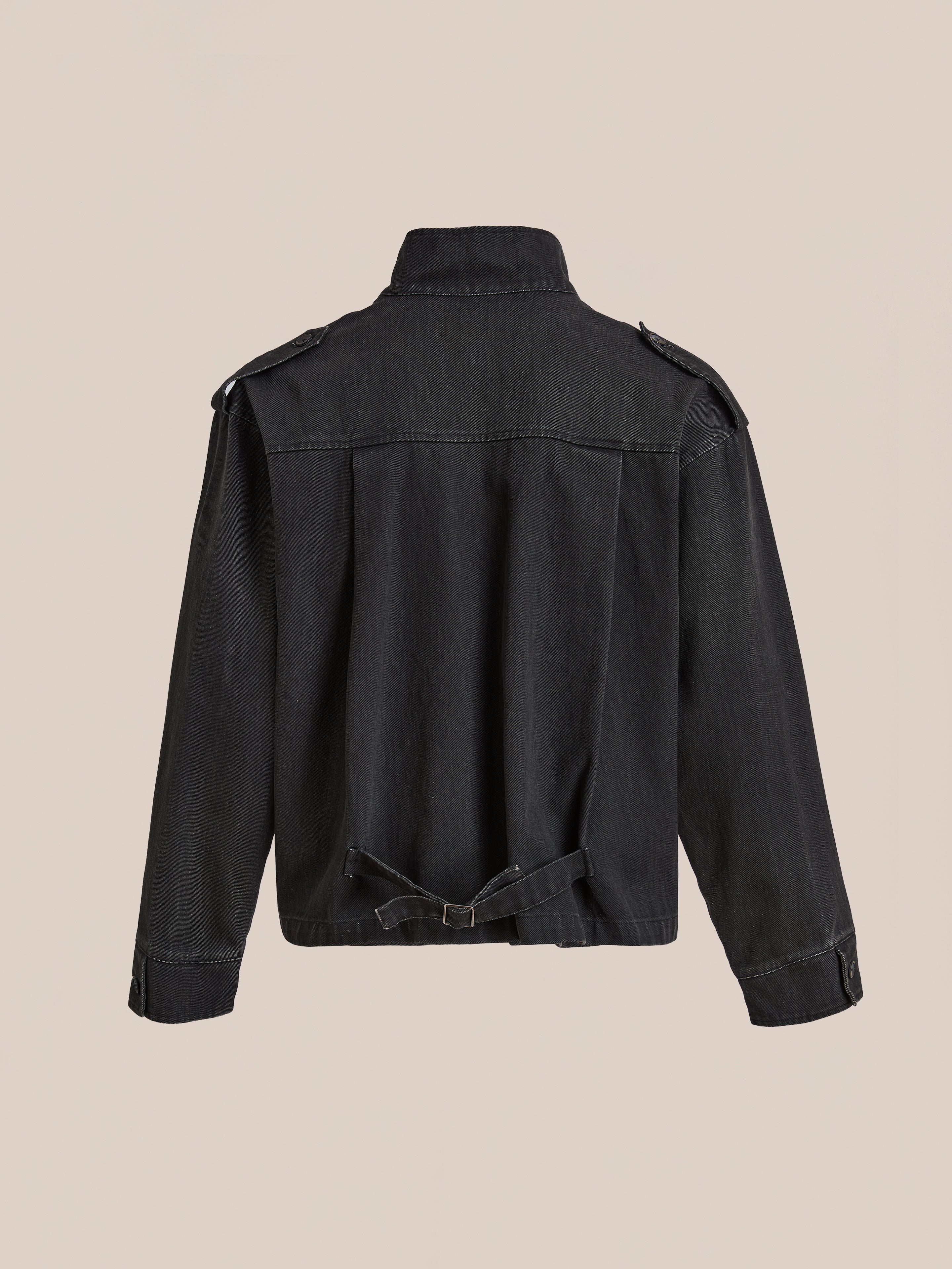 The Found Utility Clasp Work Jacket, shown in black denim from the back, features a high collar, shoulder epaulettes, and an adjustable waist strap. This unisex relaxed fit jacket delivers timeless style and versatile comfort.
