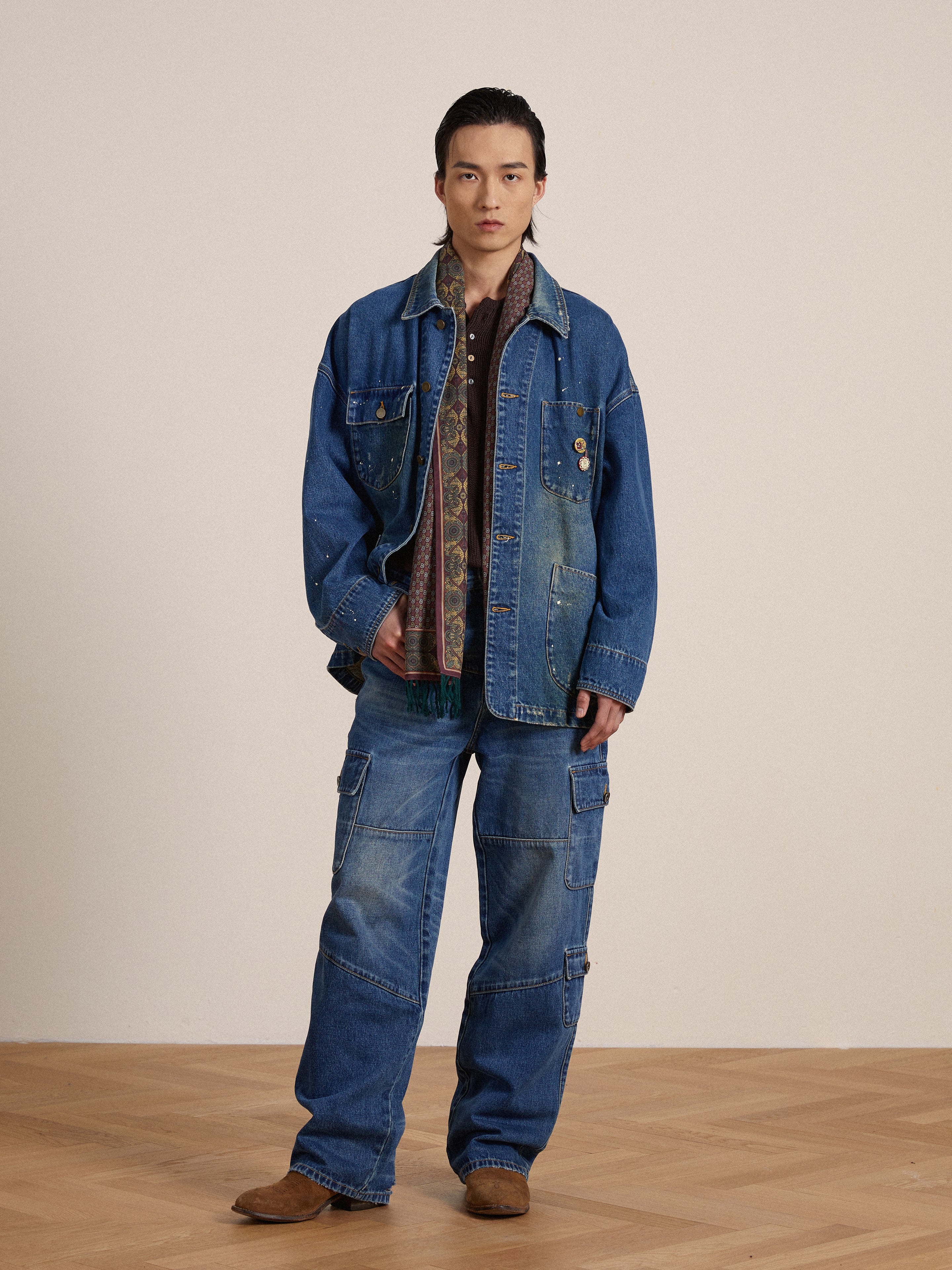A model wearing a Kavir Denim Painter Jacket and jeans, styled by an artist from Found.